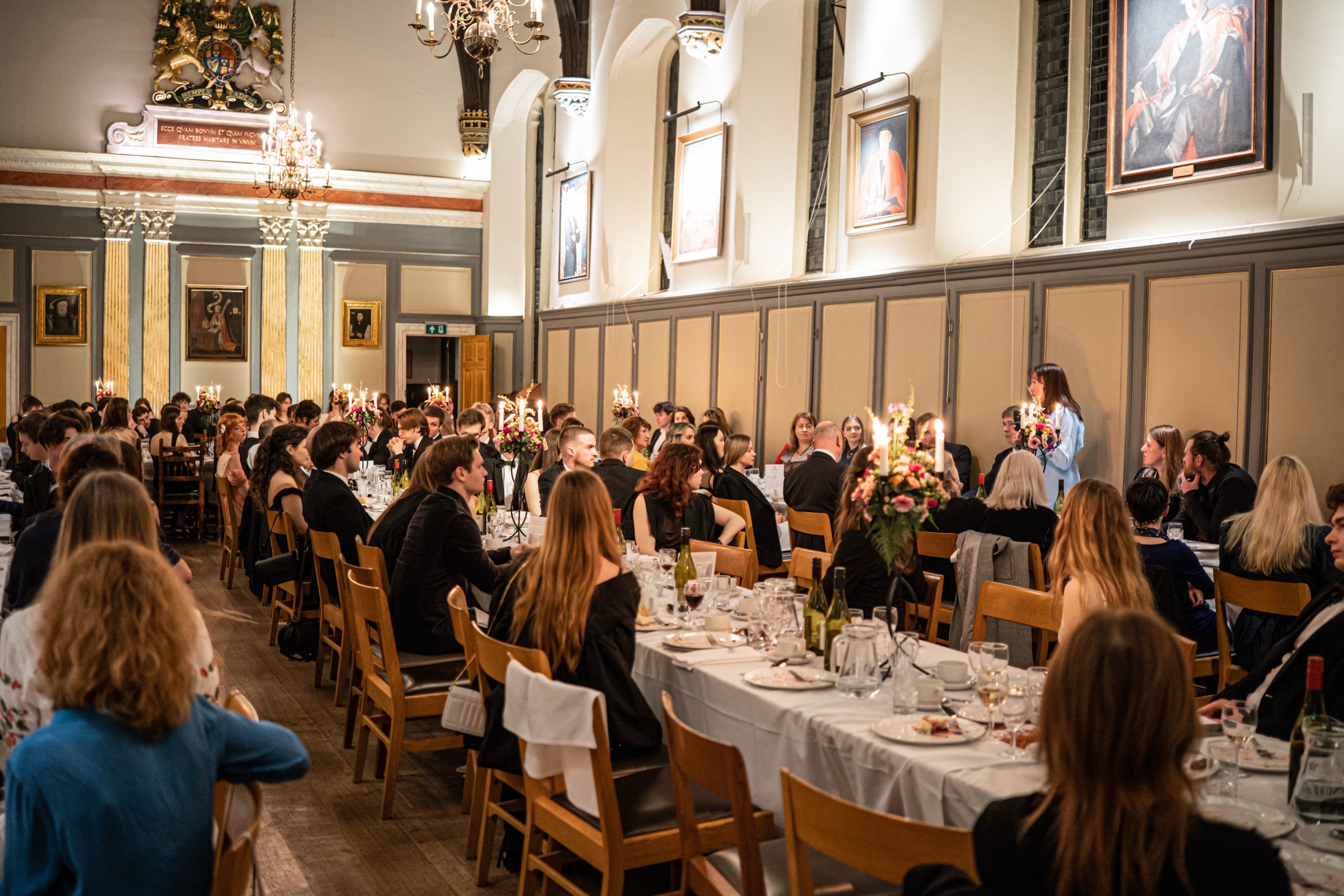 Guests at long candlelit tables in a panelled hall at the CUUS 25th anniversary dinner