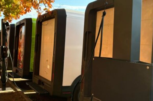 Electric delivery vans parked at a distribution hub illustrating sustainable last-mile delivery