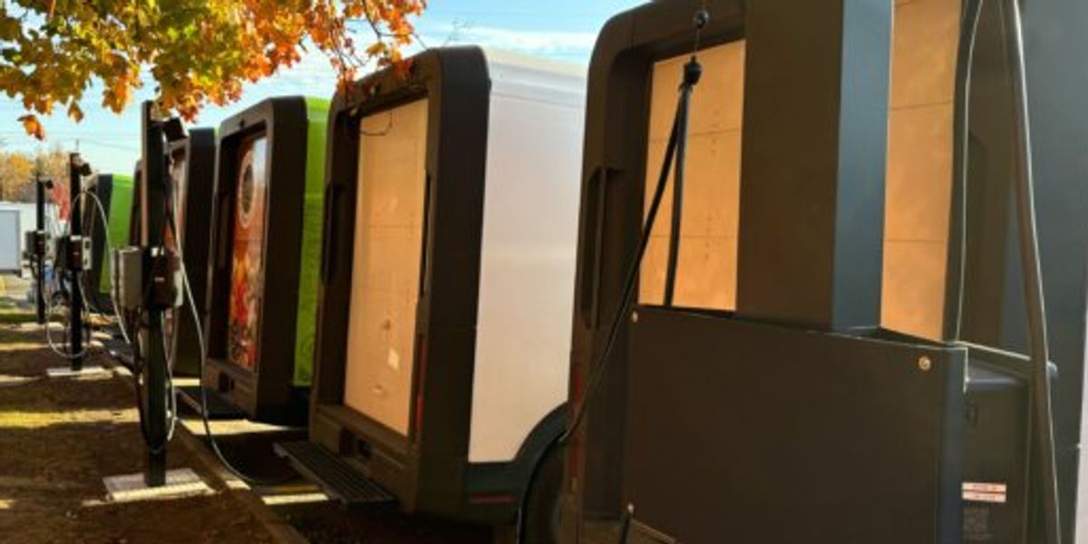 Electric delivery vans parked at a distribution hub illustrating sustainable last-mile delivery