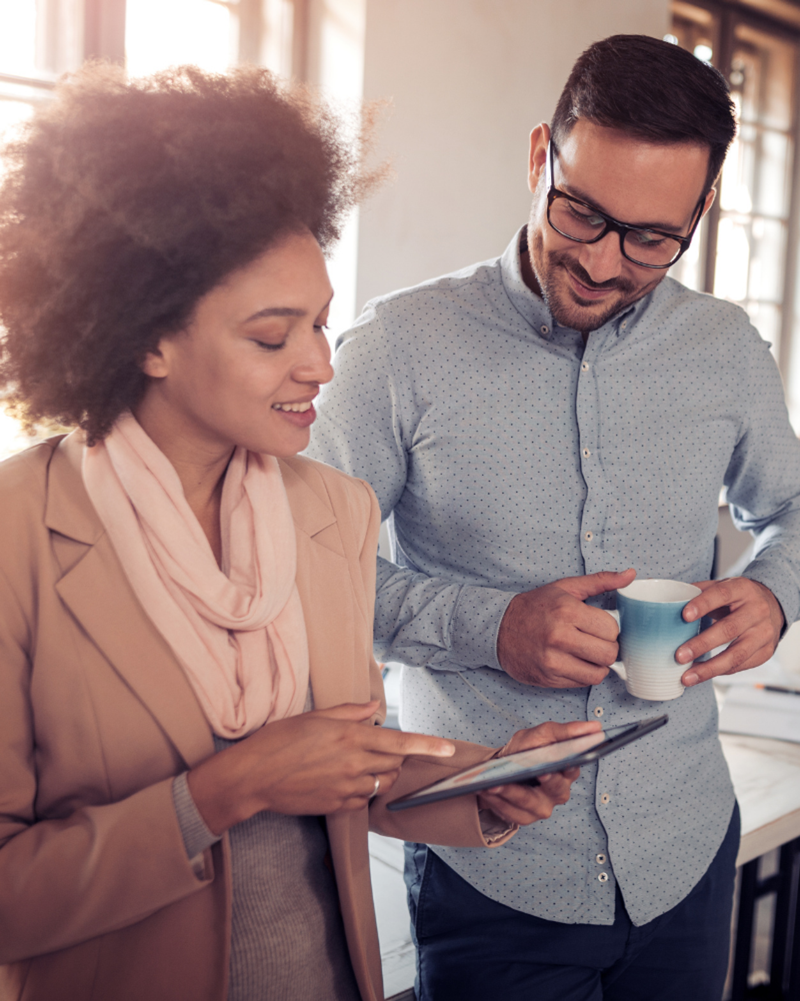 Photo of two people looking at a tablet.