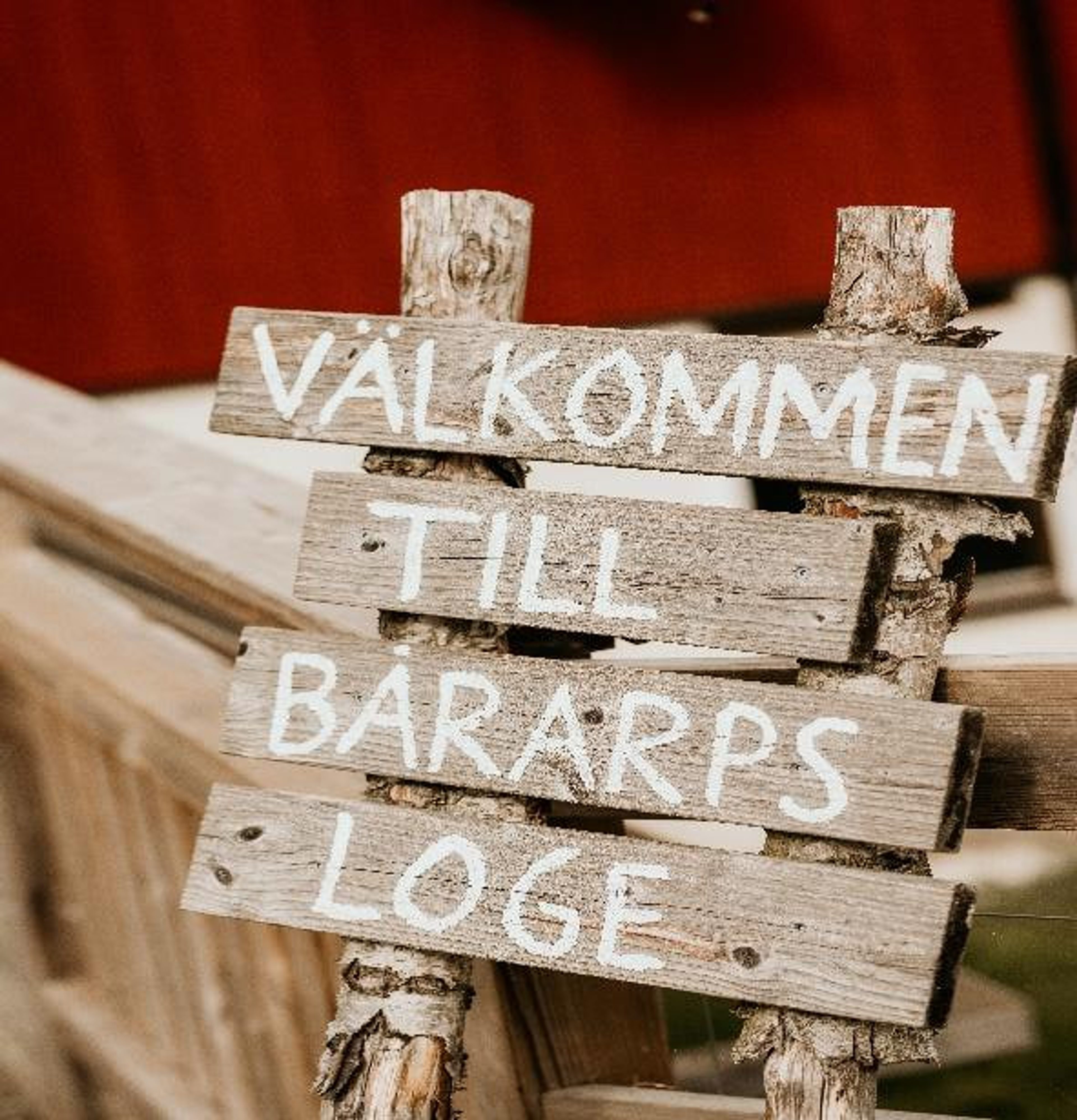 Handmålad träskylt med texten Välkommen till Bårarps loge