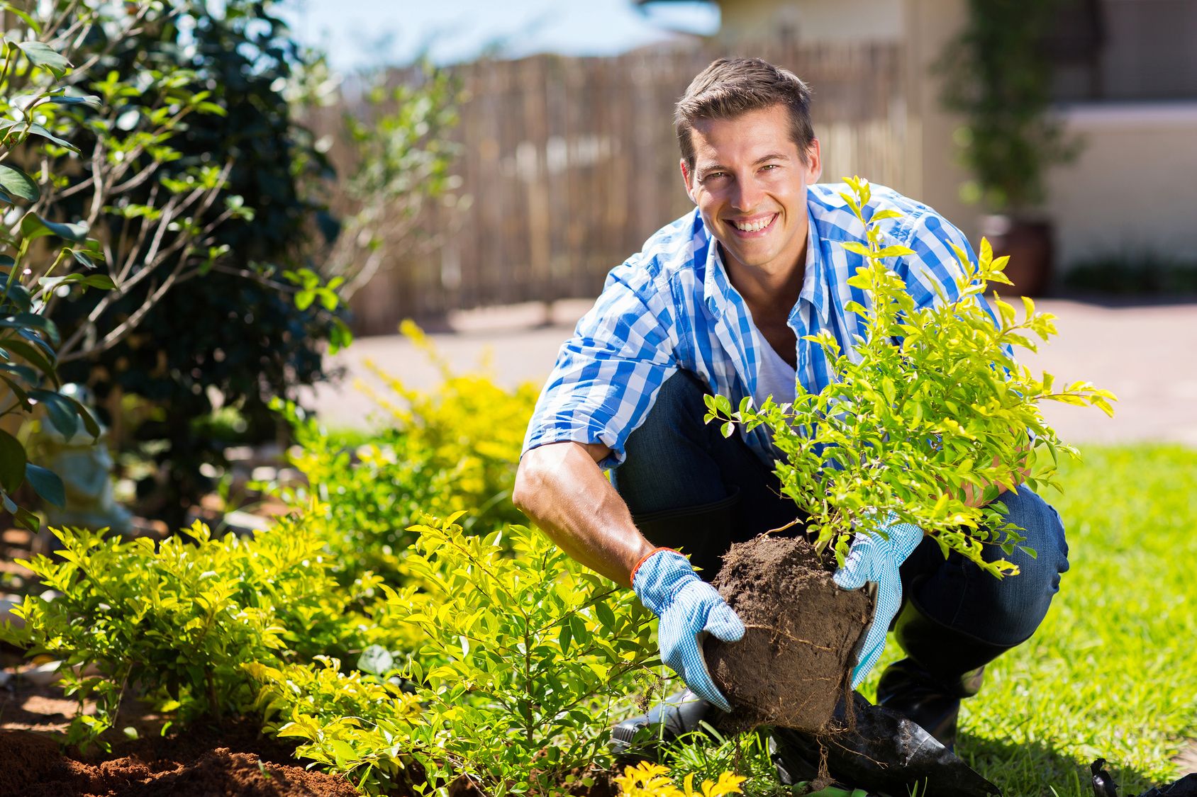 happy young man gardening in backyard
