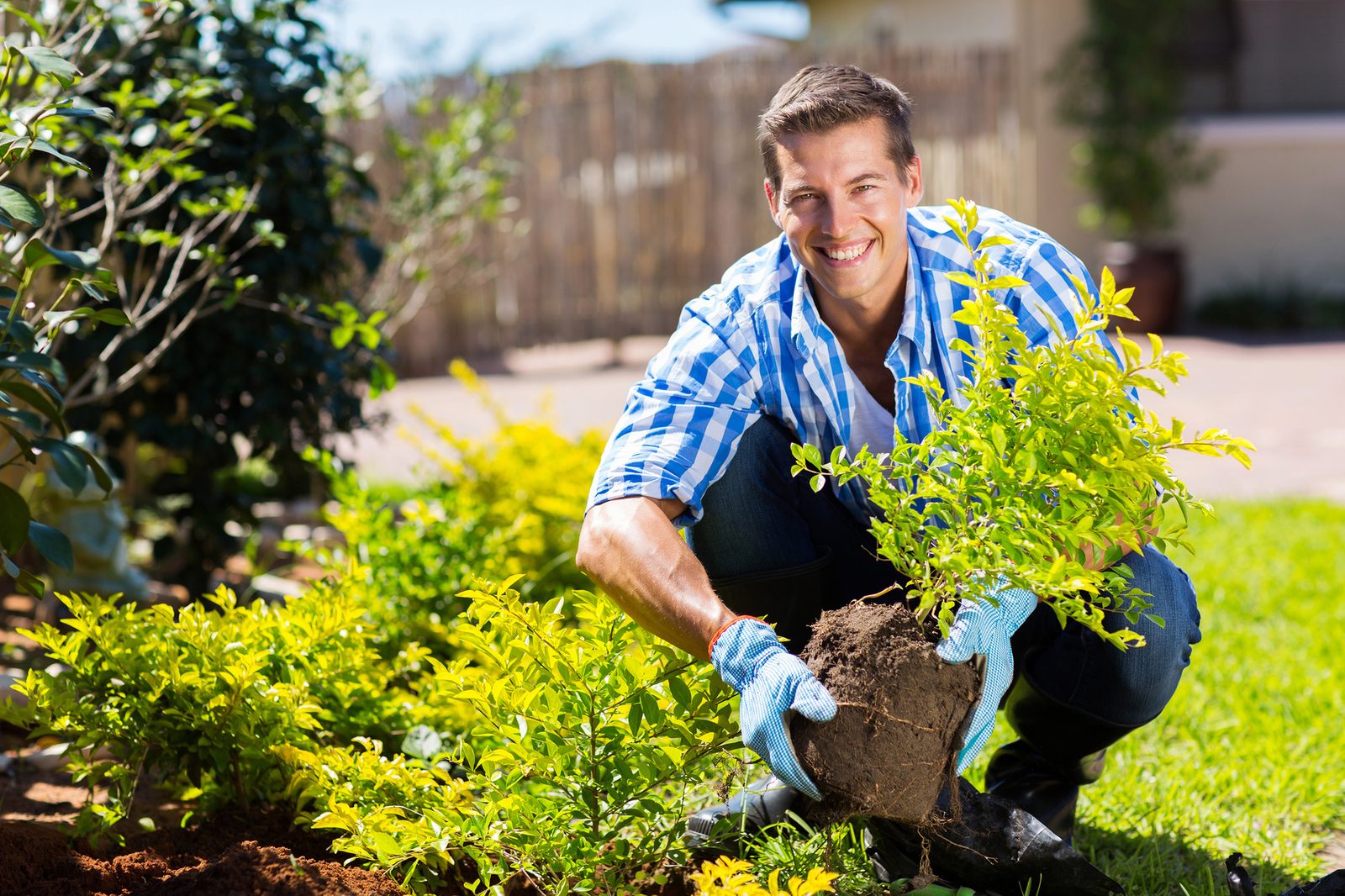 happy young man gardening in backyard