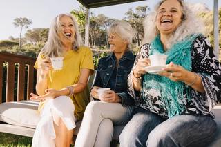Ladies drinking coffee outside laughing