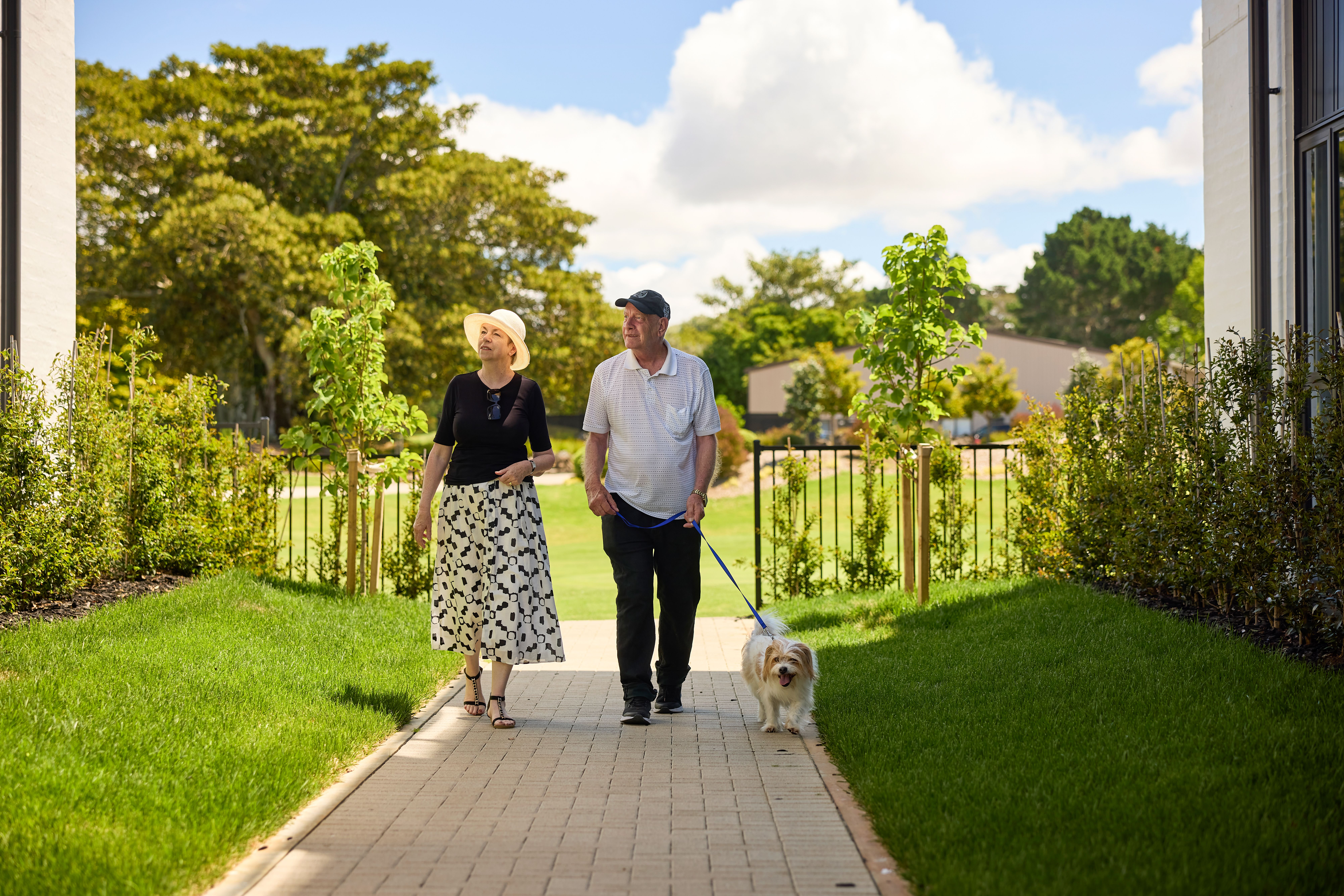 Residents walking their dog through the village grounds at Fairway Gardens