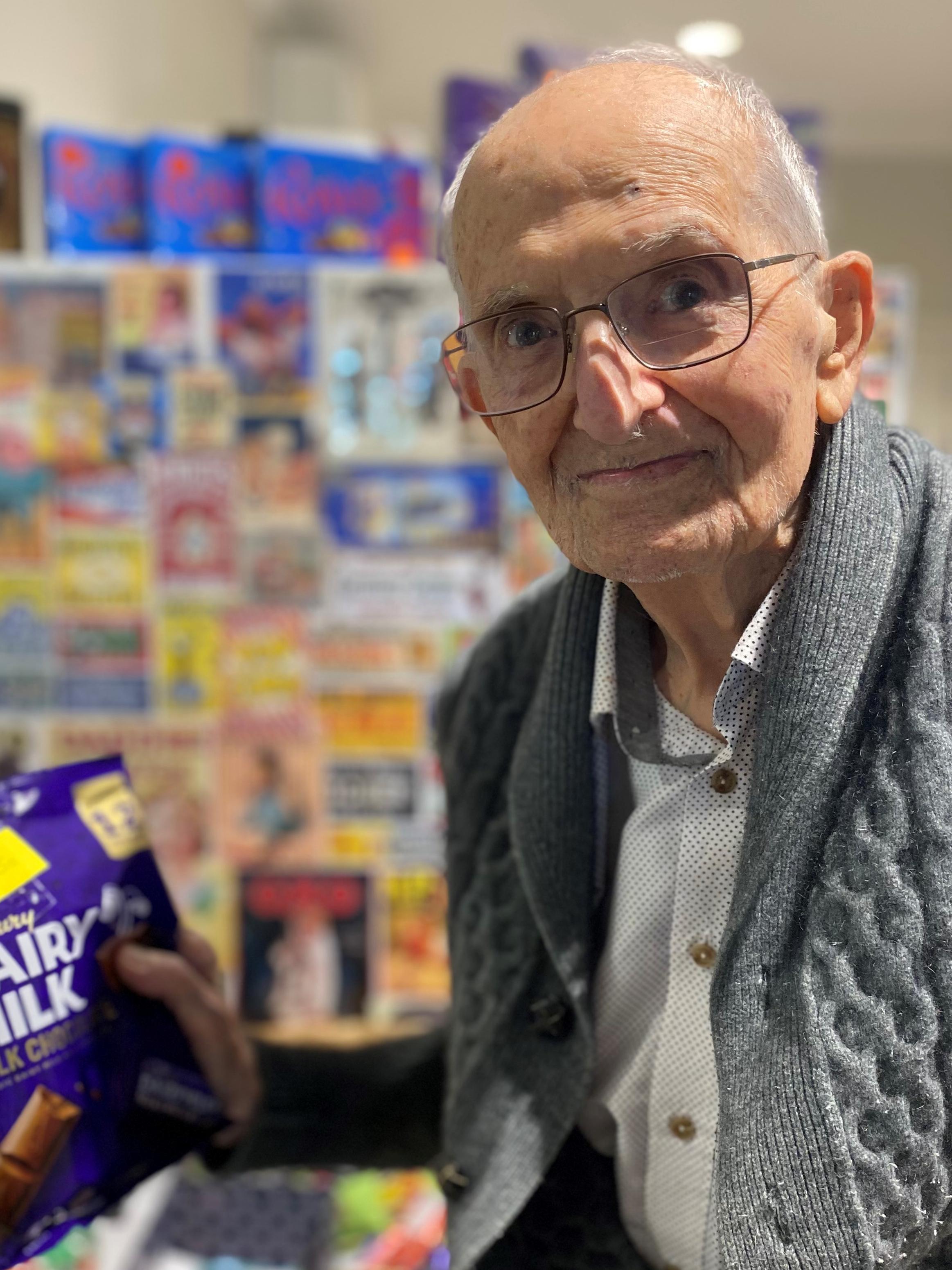 John with his favourite chocolate in the village store