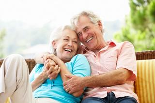 Elderly couple smiling and hugging warmly