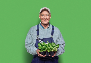 Man holding vegetables smiling at a retirement village