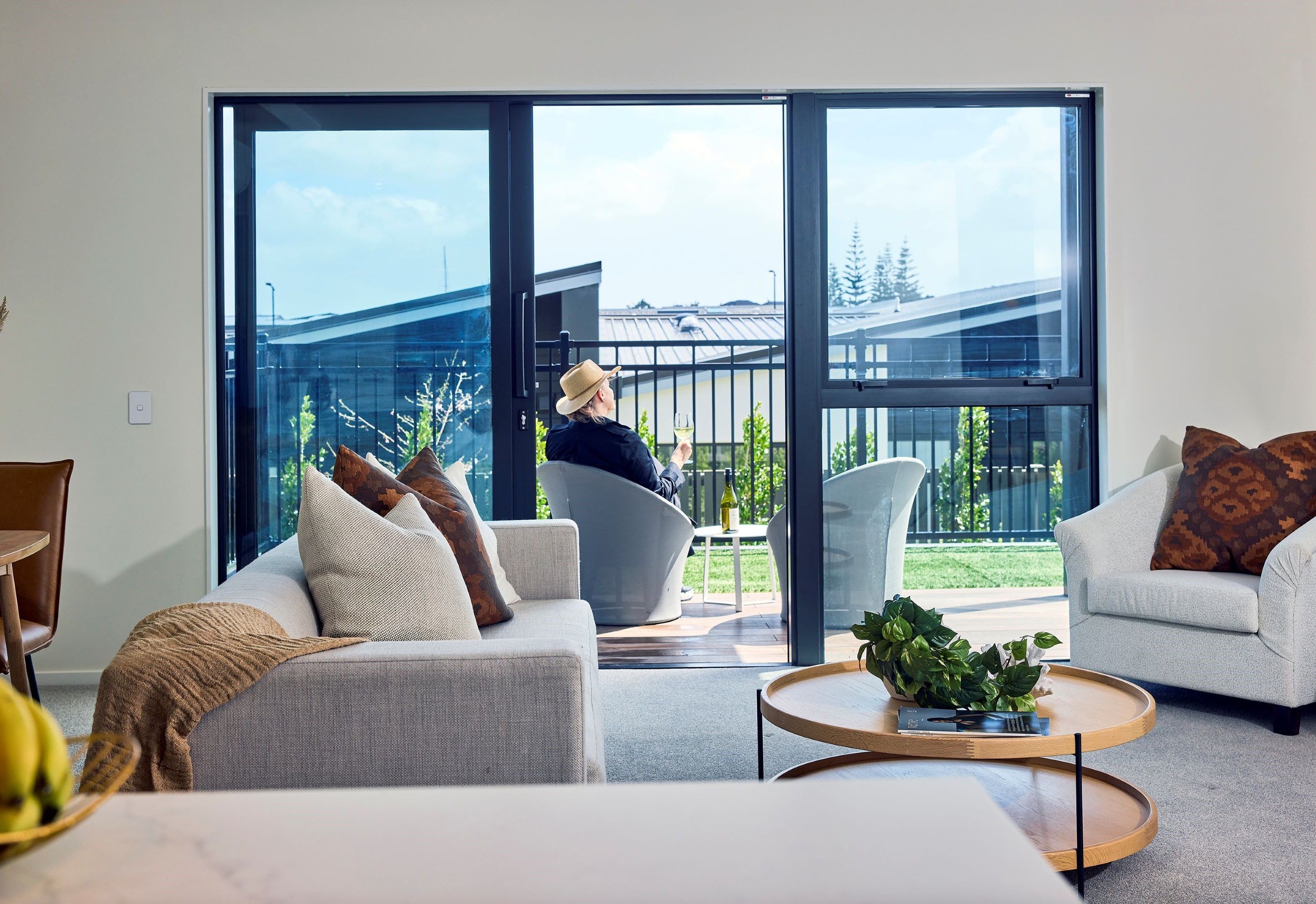 Resident sitting on her apartment patio at Pōhutukawa Landing