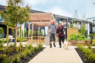 Couple walking through the village with their dog