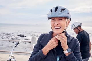 Resident smiling while riding bike along beach