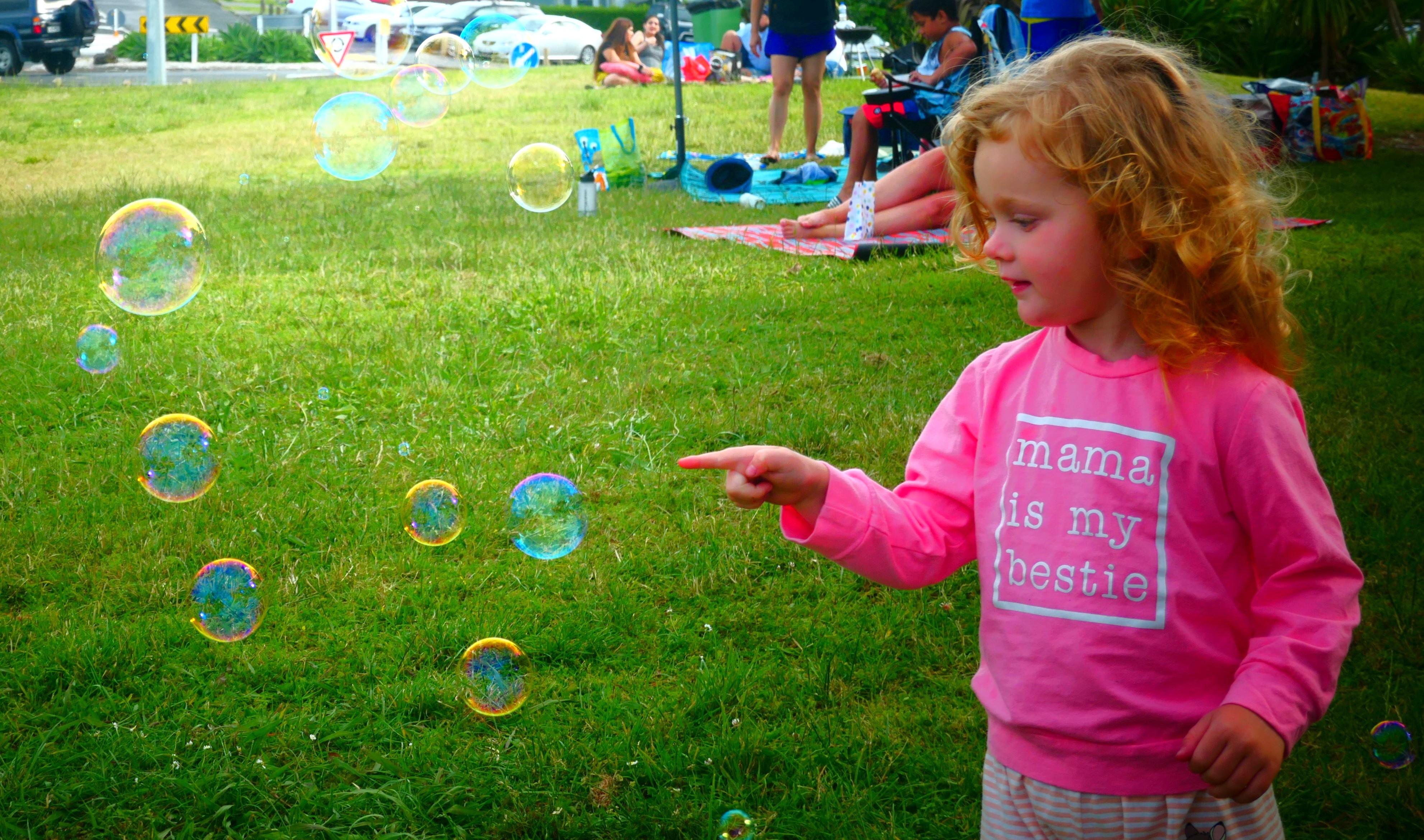 Max’s granddaughter trying to pop bubbles at their family picnic.