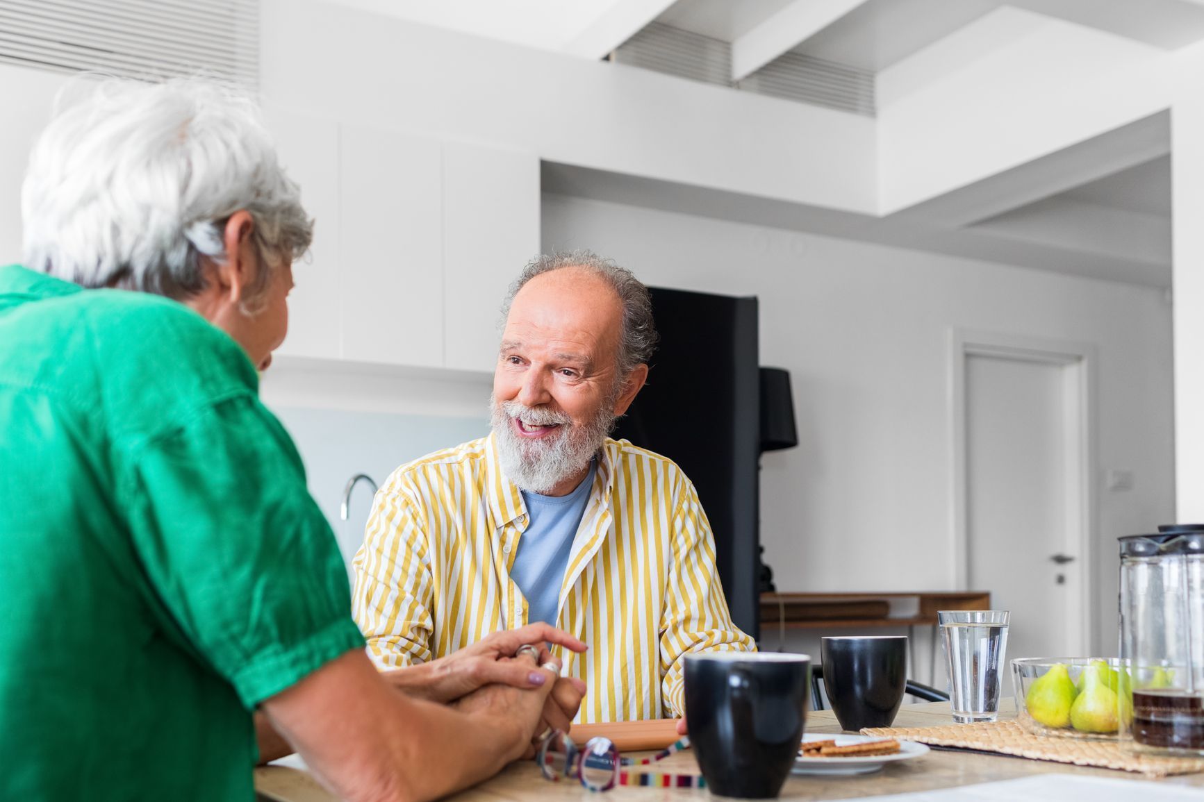 Couple chatting in the dining room of their assisted living having tea and coffee