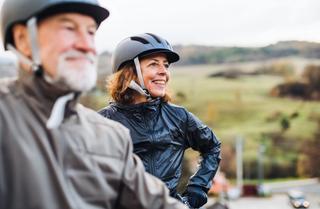 Residents riding their bikes along the beach smiling