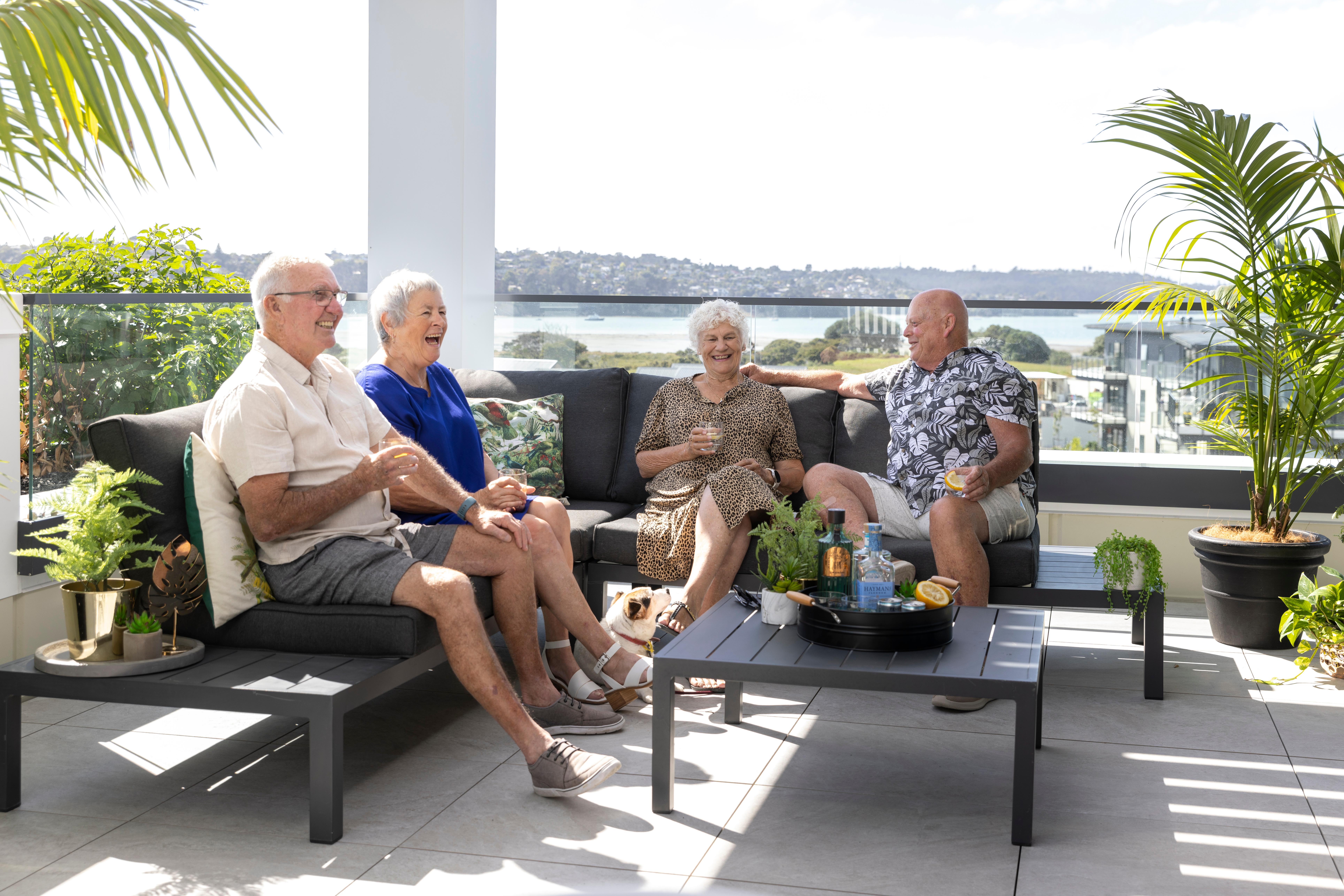 Orion Point residents on the balcony with view of Hobsonville in the back