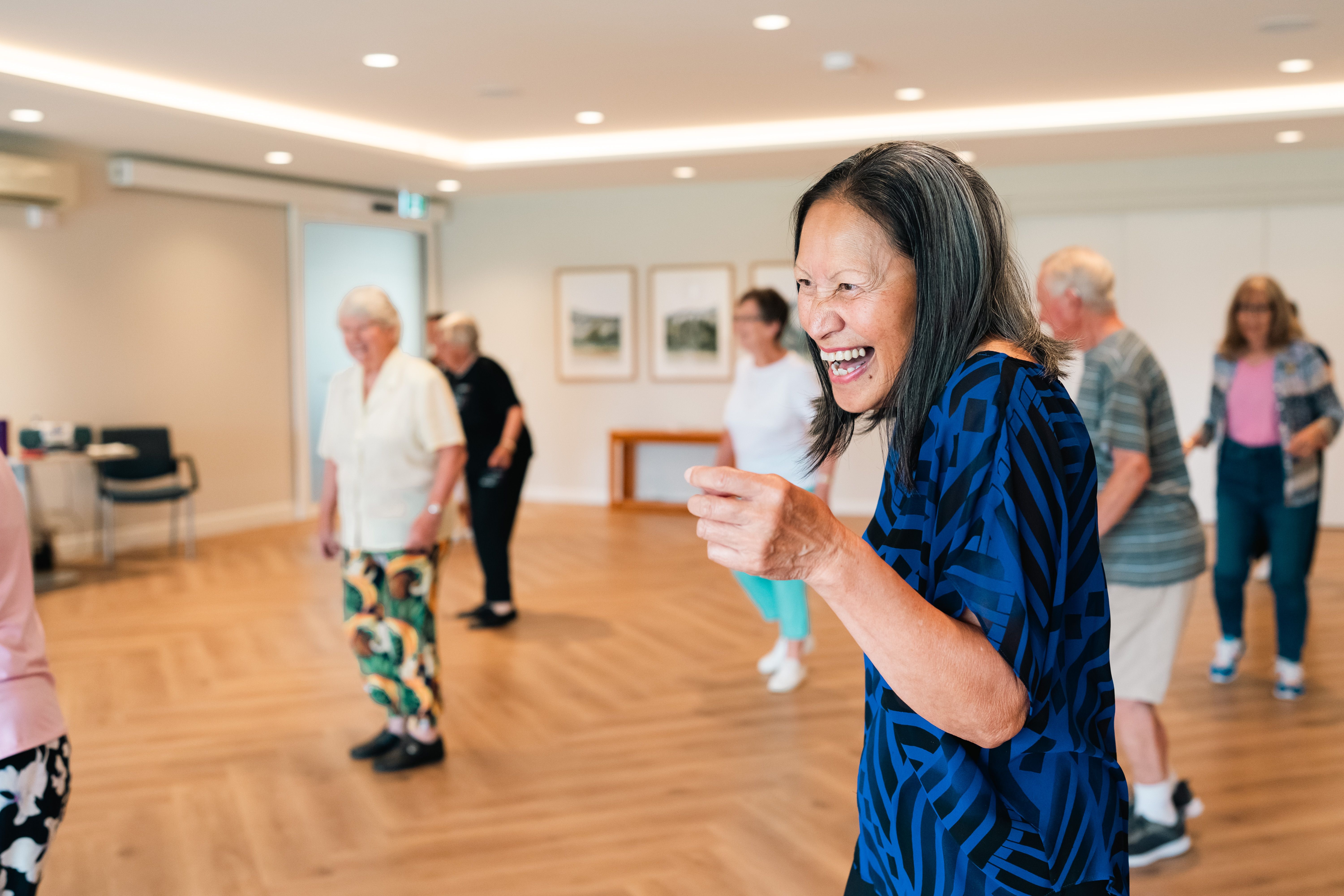 Residents in communal area doing line dancing