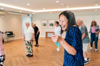 Residents in communal area doing line dancing