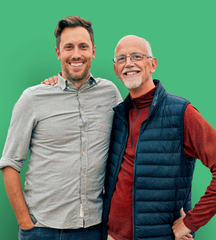 Father and son smiling on green
