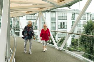 Residents walking across the sky bridge at Waitākere Gardens