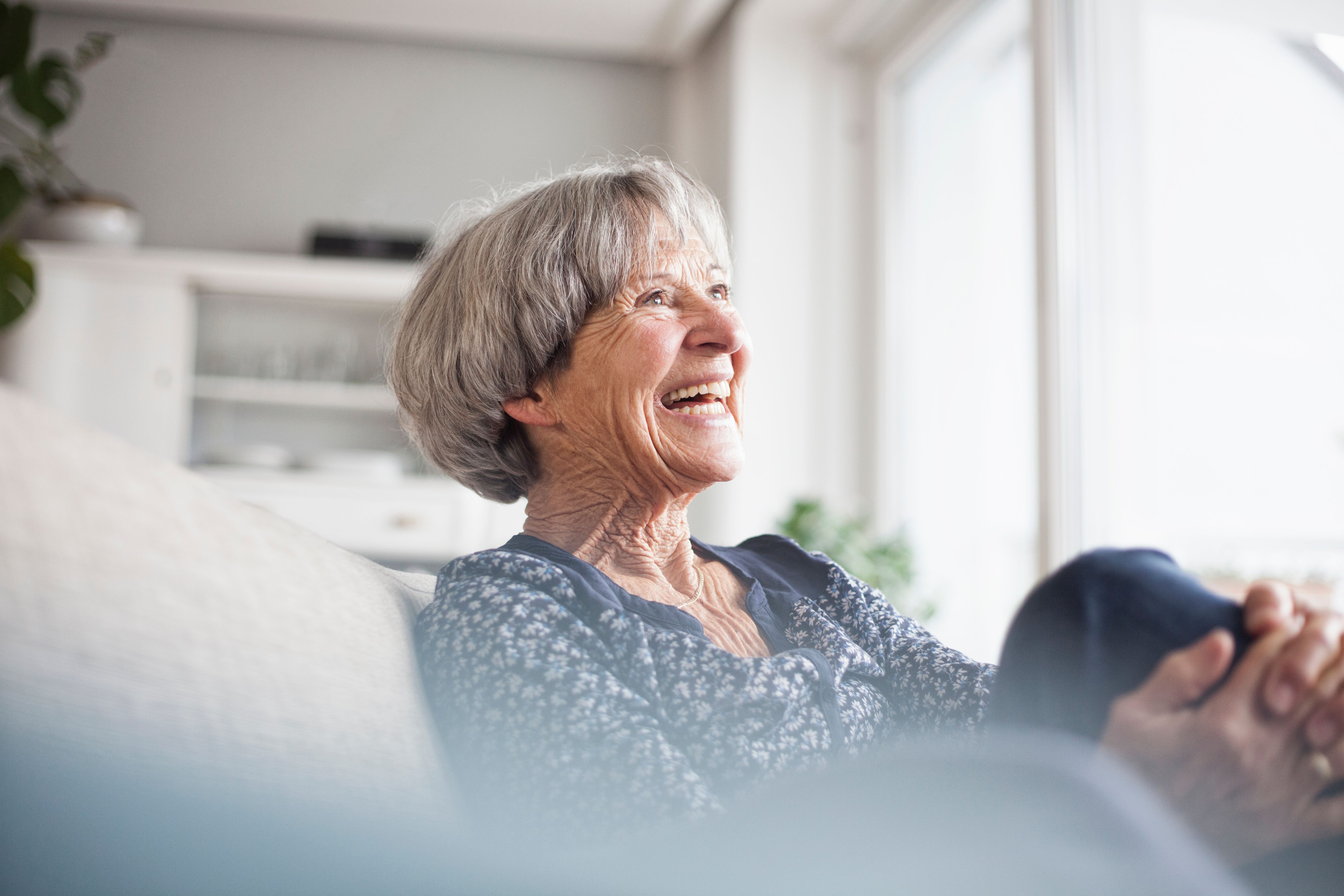 Woman sitting down in her assisted living care suite