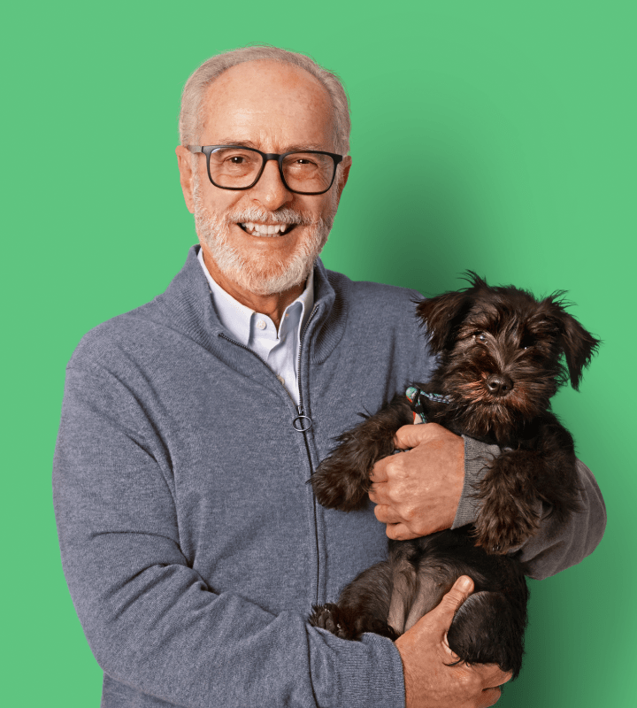 Residents smiling with dog on green