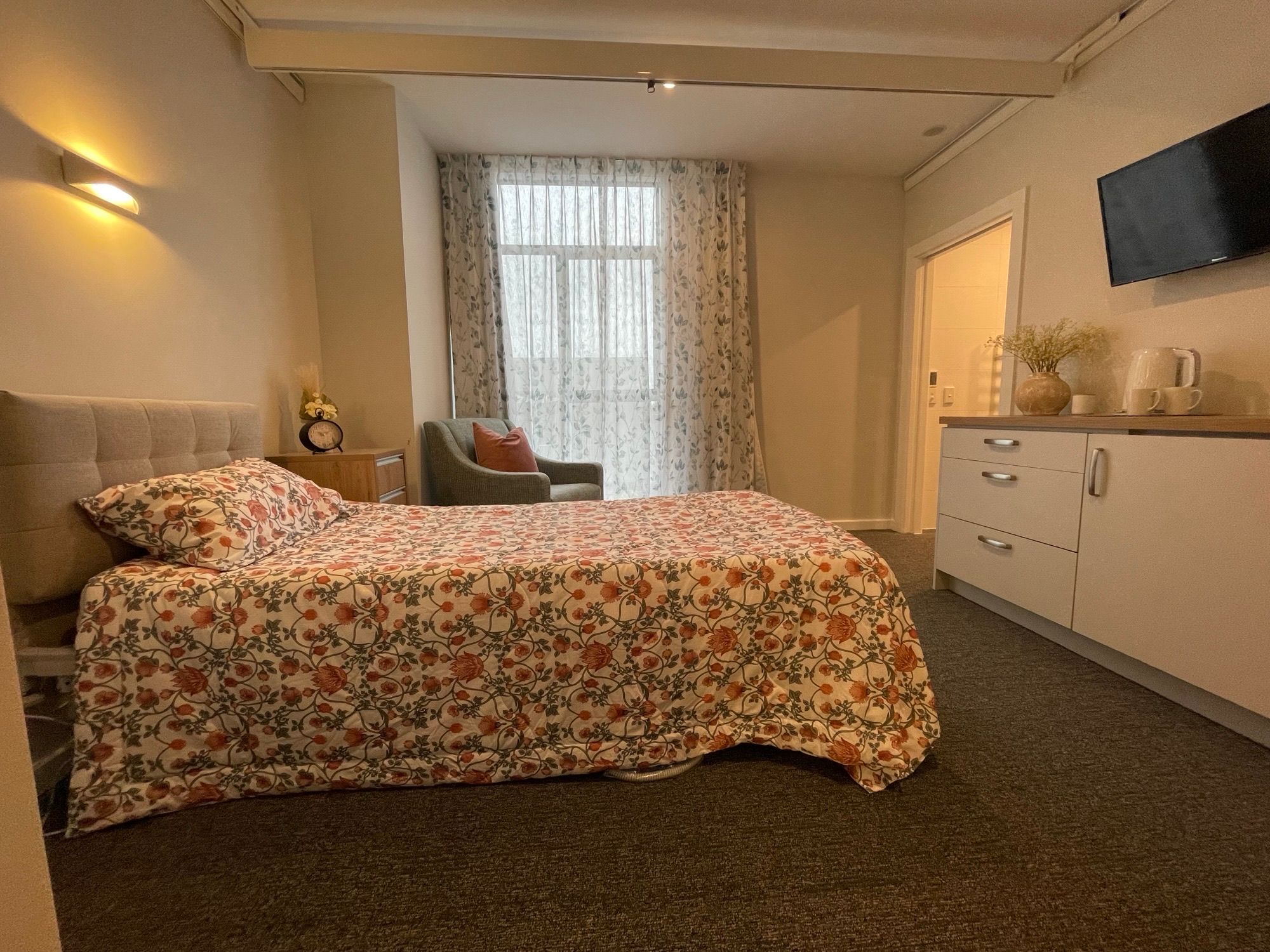 Image of a care room with a bed, chair and kitchenette