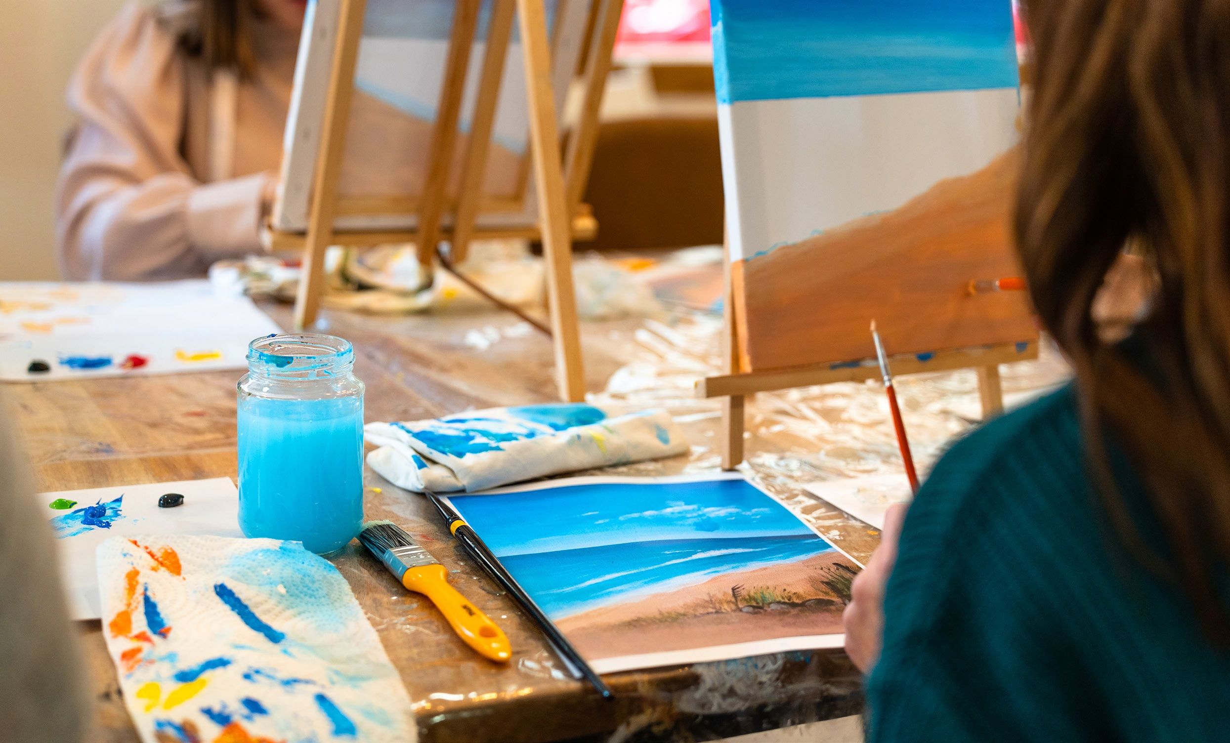 Residents painting a landscape on a canvas