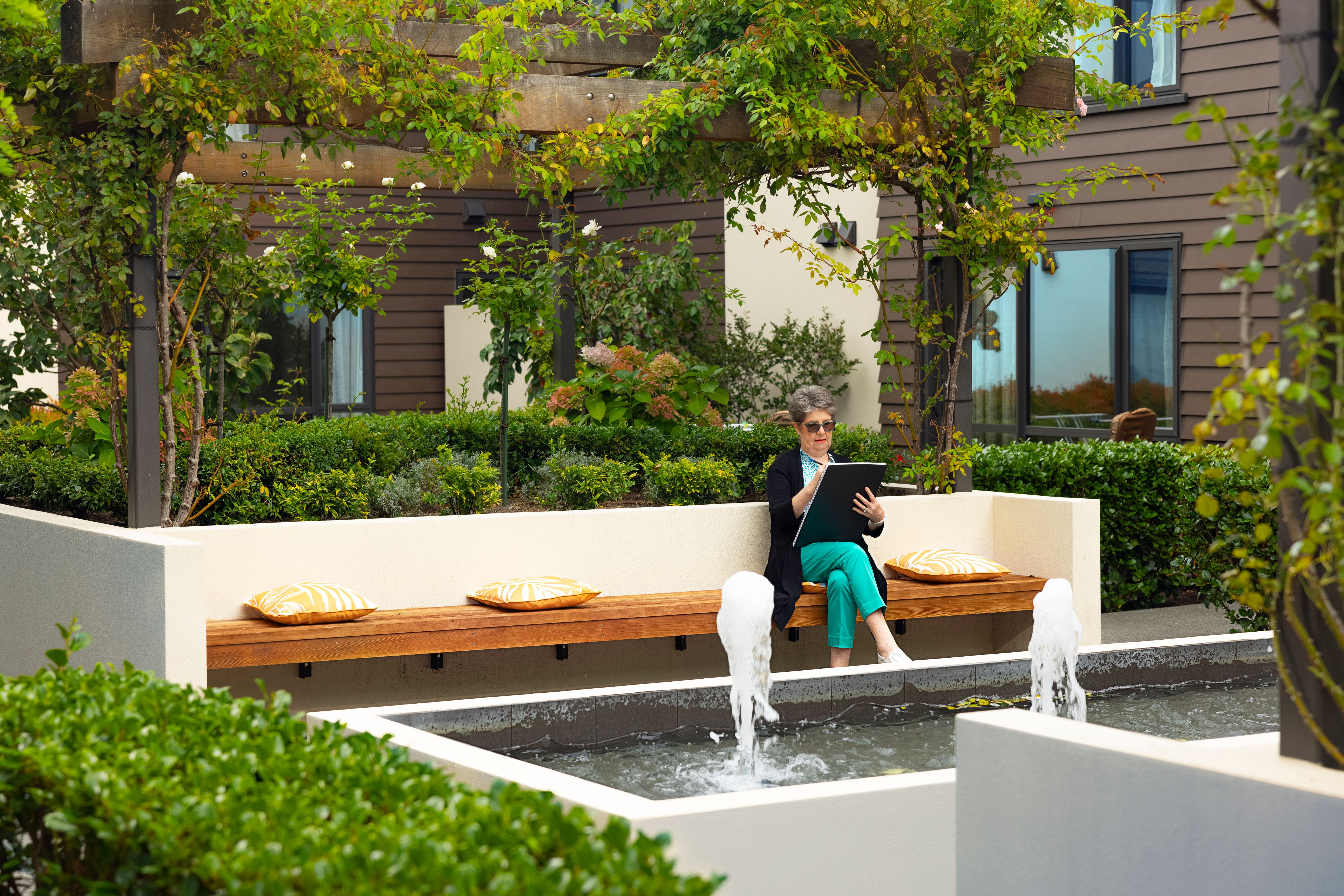 Resident reading a book in the courtyard at The Village Palms