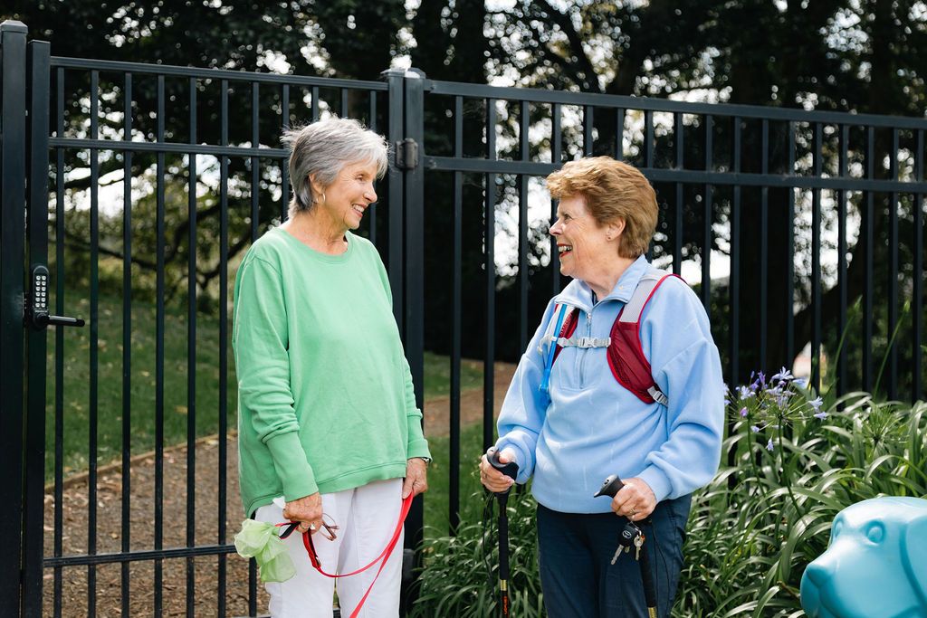 Residents smiling and walking dog in park