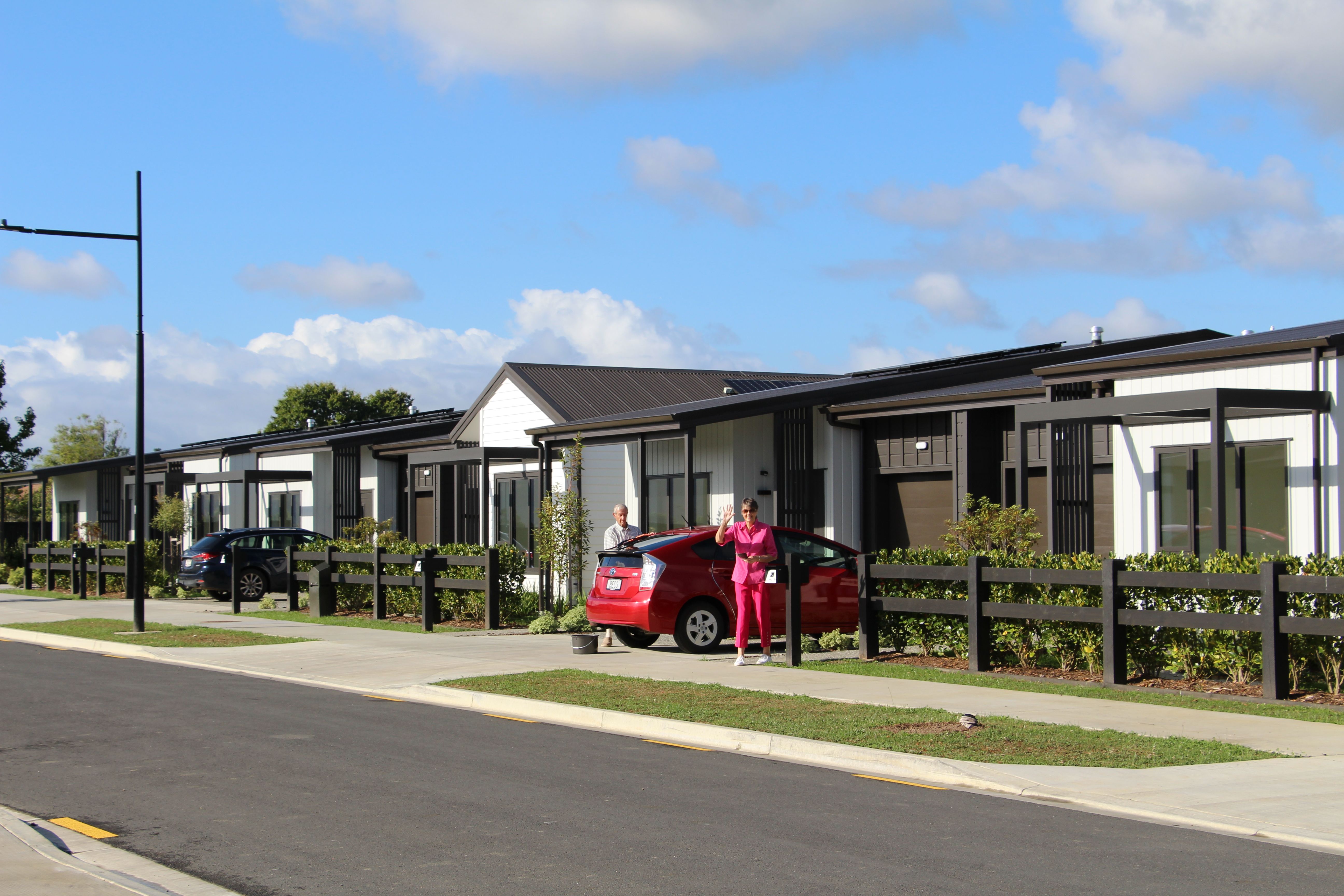 Residents waving to neighbor outside their villa