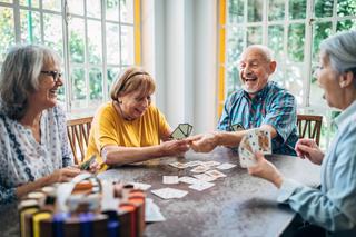 Stock image of friends chatting while enjoying card games