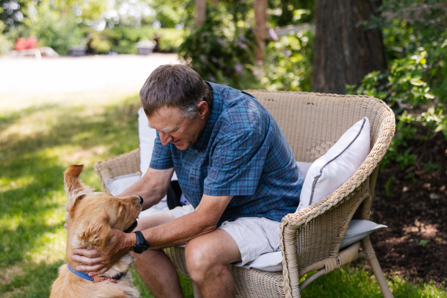 Man patting his dog in a park