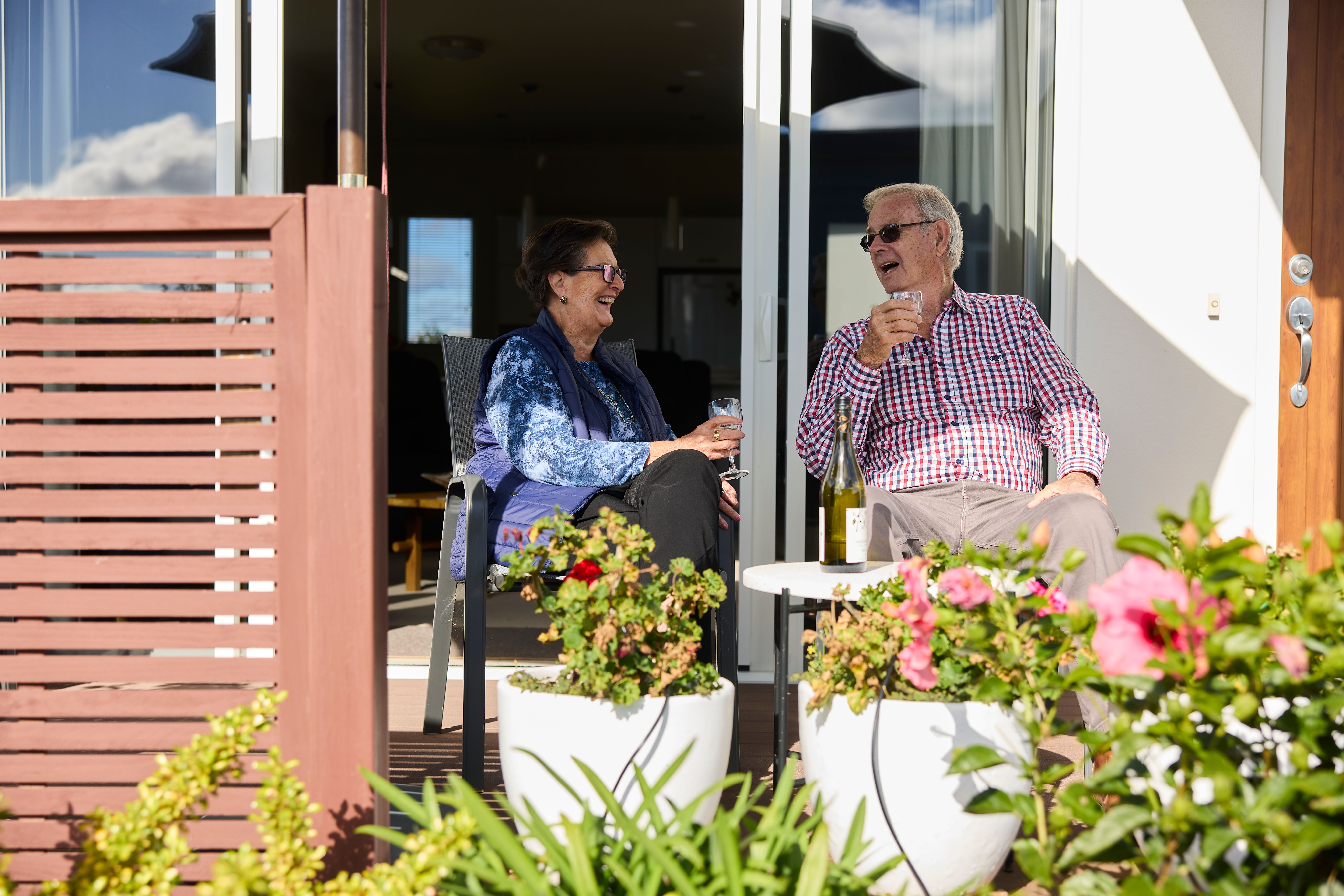 Residents sitting on their patio talking outside and smiling