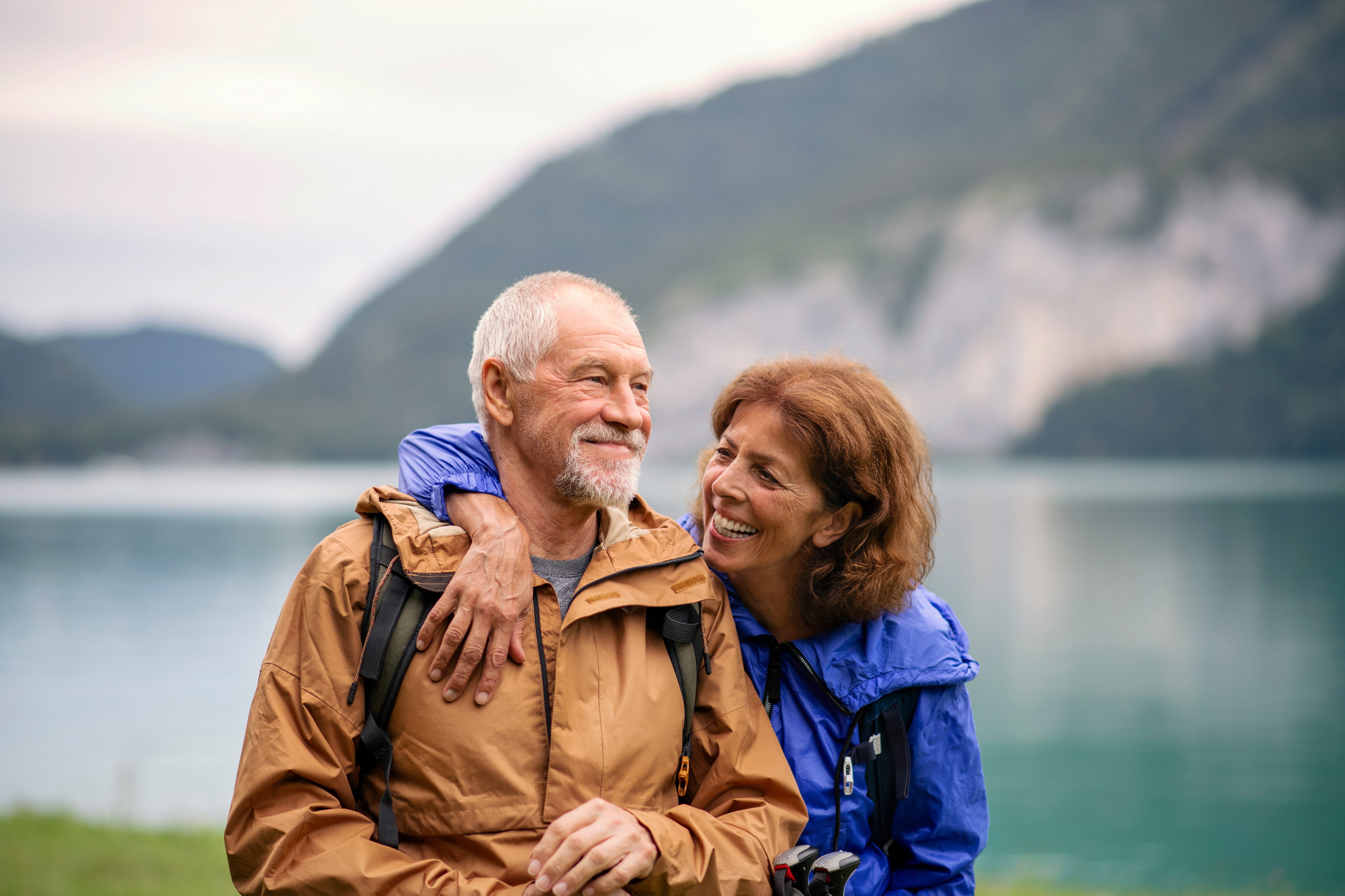Couple travelling with lake behind them