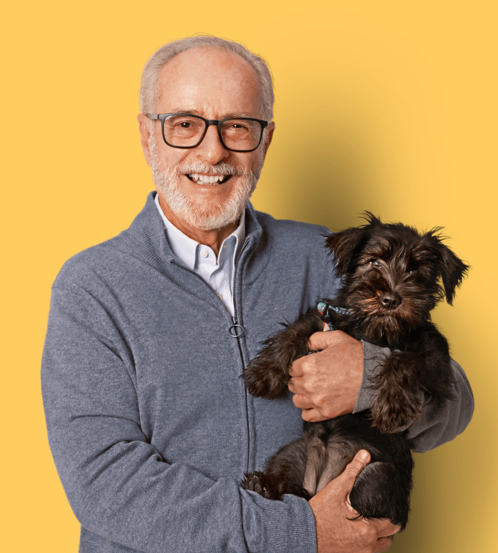 Man holding dog and smiling
