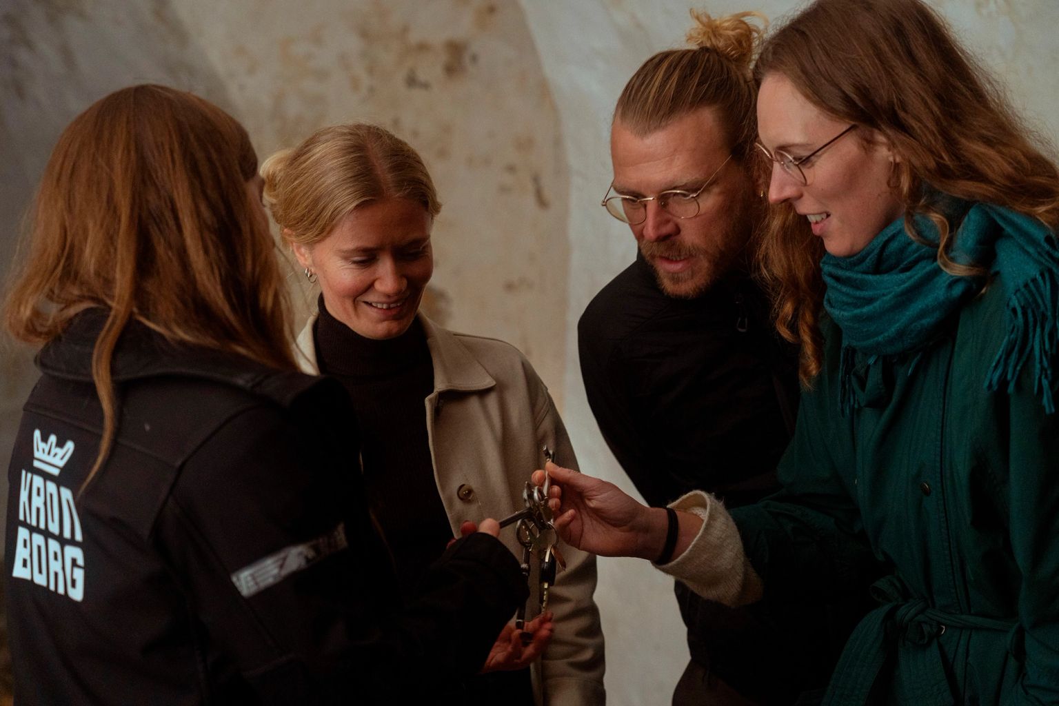 Four people look at historical keys together.