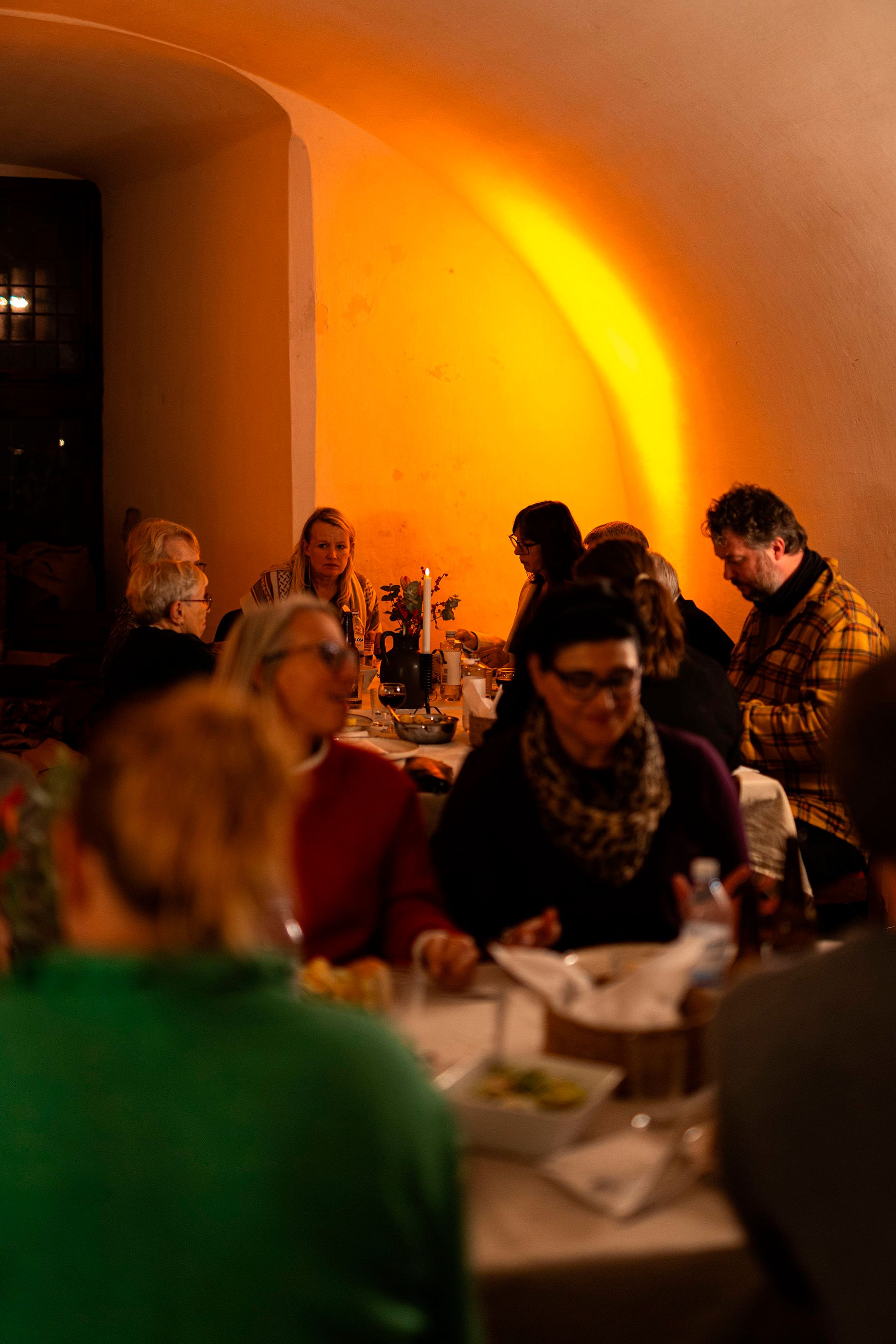 Guests dining in warm lighting.