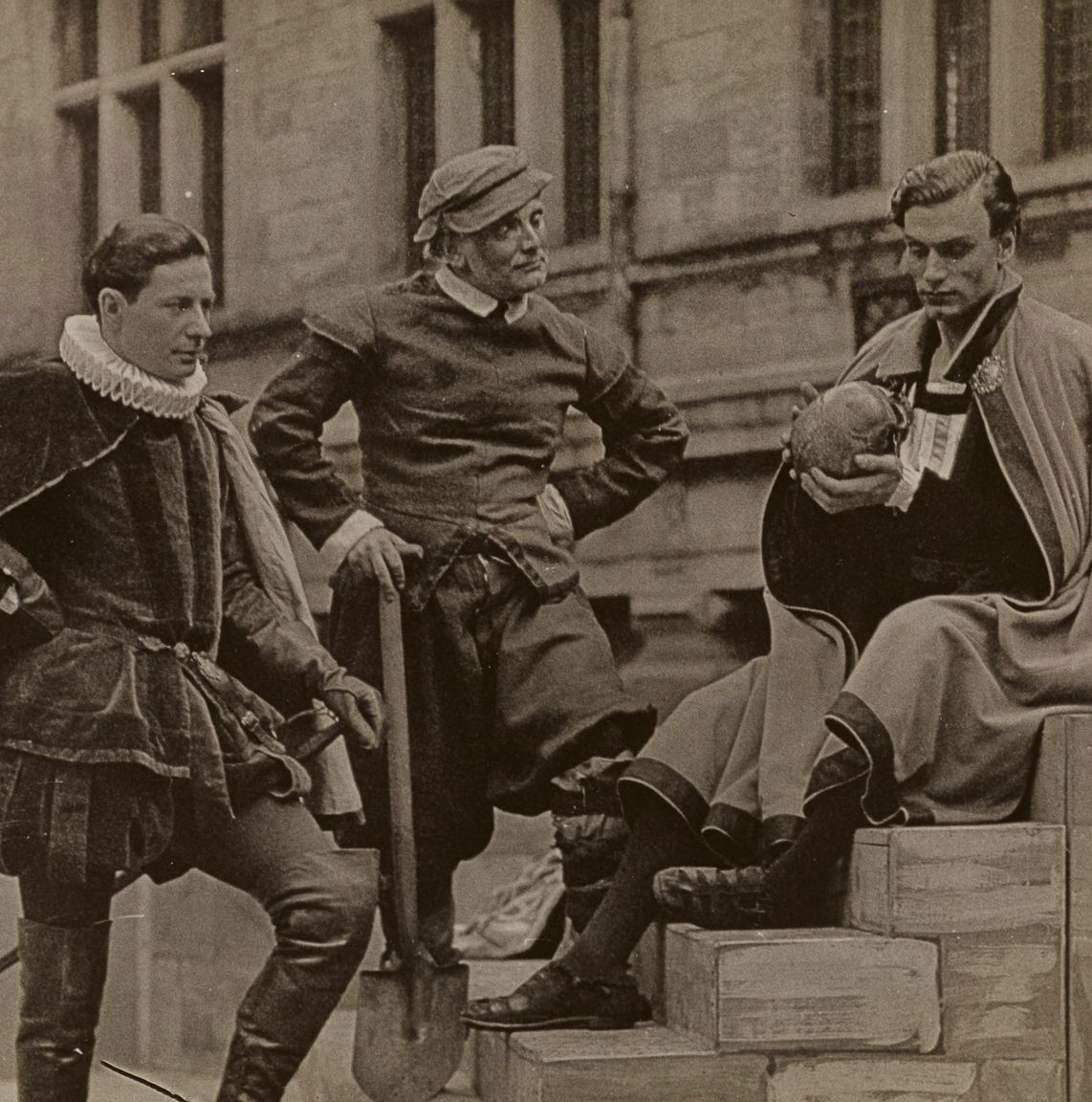 Historisk arkivfoto af tre skuespillere i renæssancekostumer på trapper foran Kronborgs facade – tidlig Hamlet-opførelse på slottet