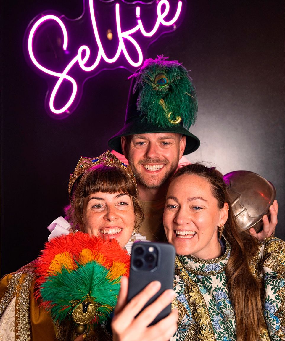 Three costumed people taking a festive selfie.
