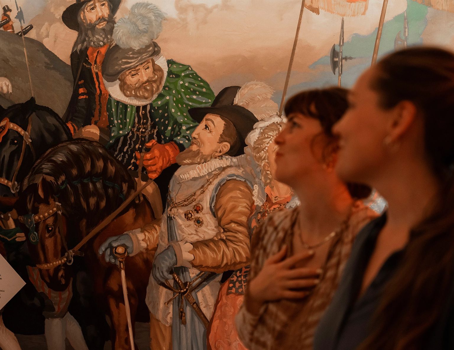 To kvinder ser på et historisk maleri i et museum