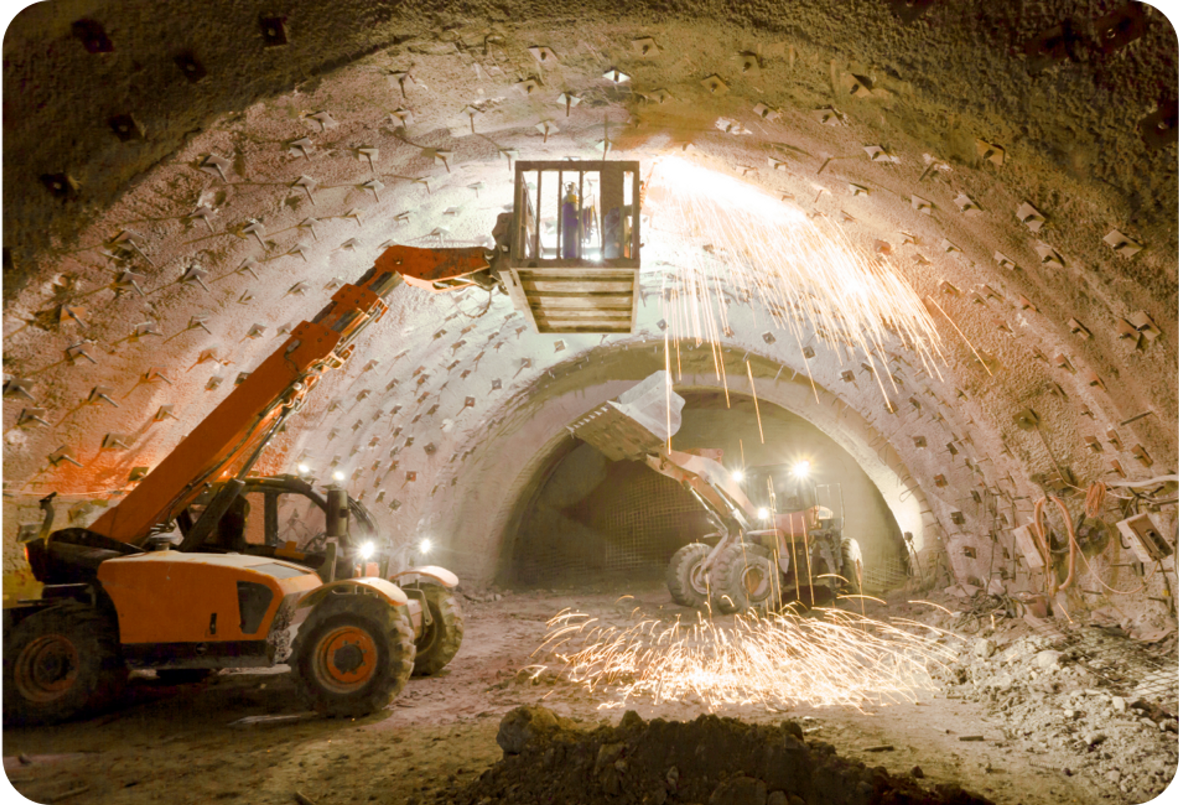 Picture of two lift trucks inside a mine tunnel with a man inside one of the lift truck boxes