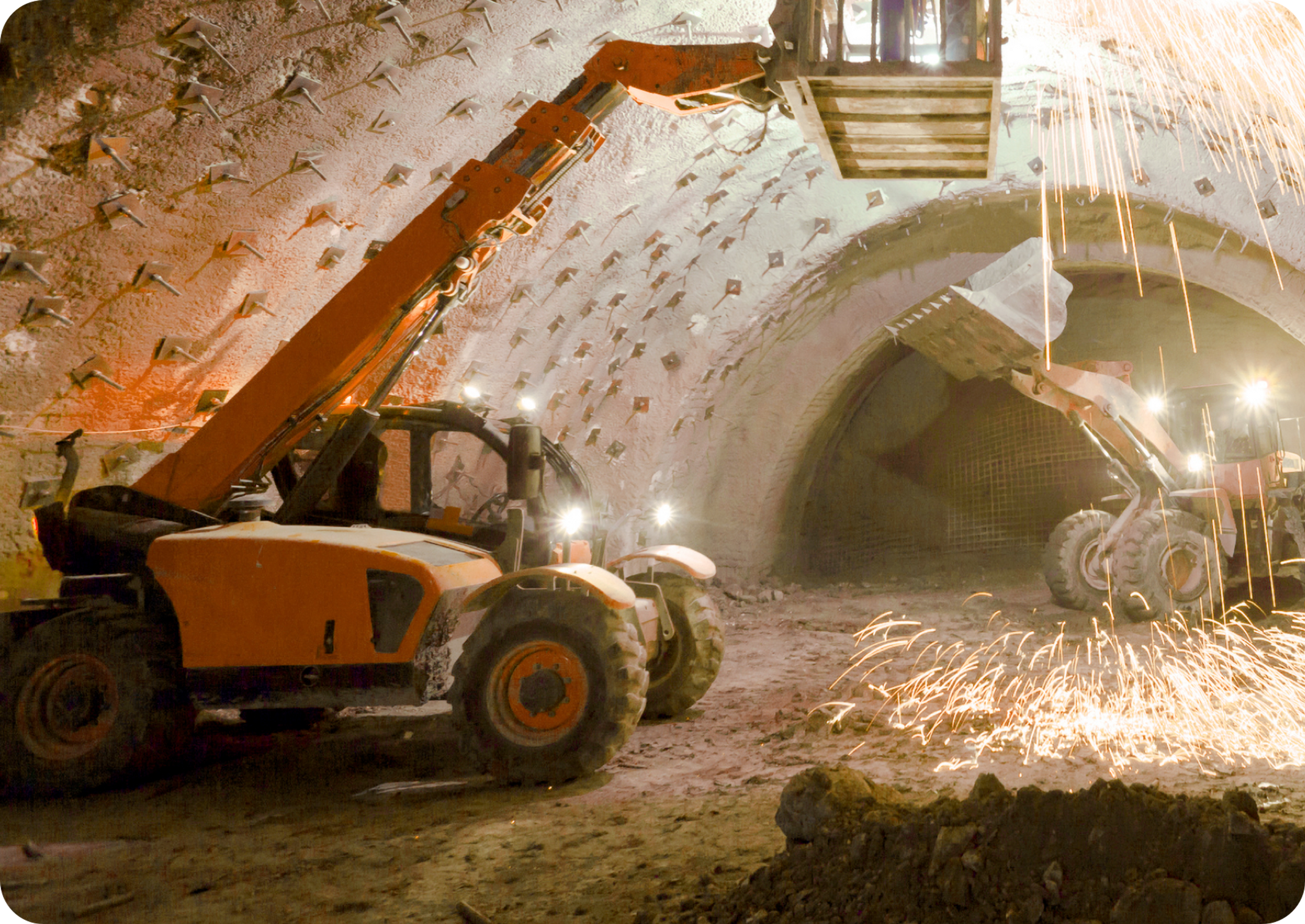 Picture of two lift trucks inside a mine tunnel with a man inside one of the lift truck boxes