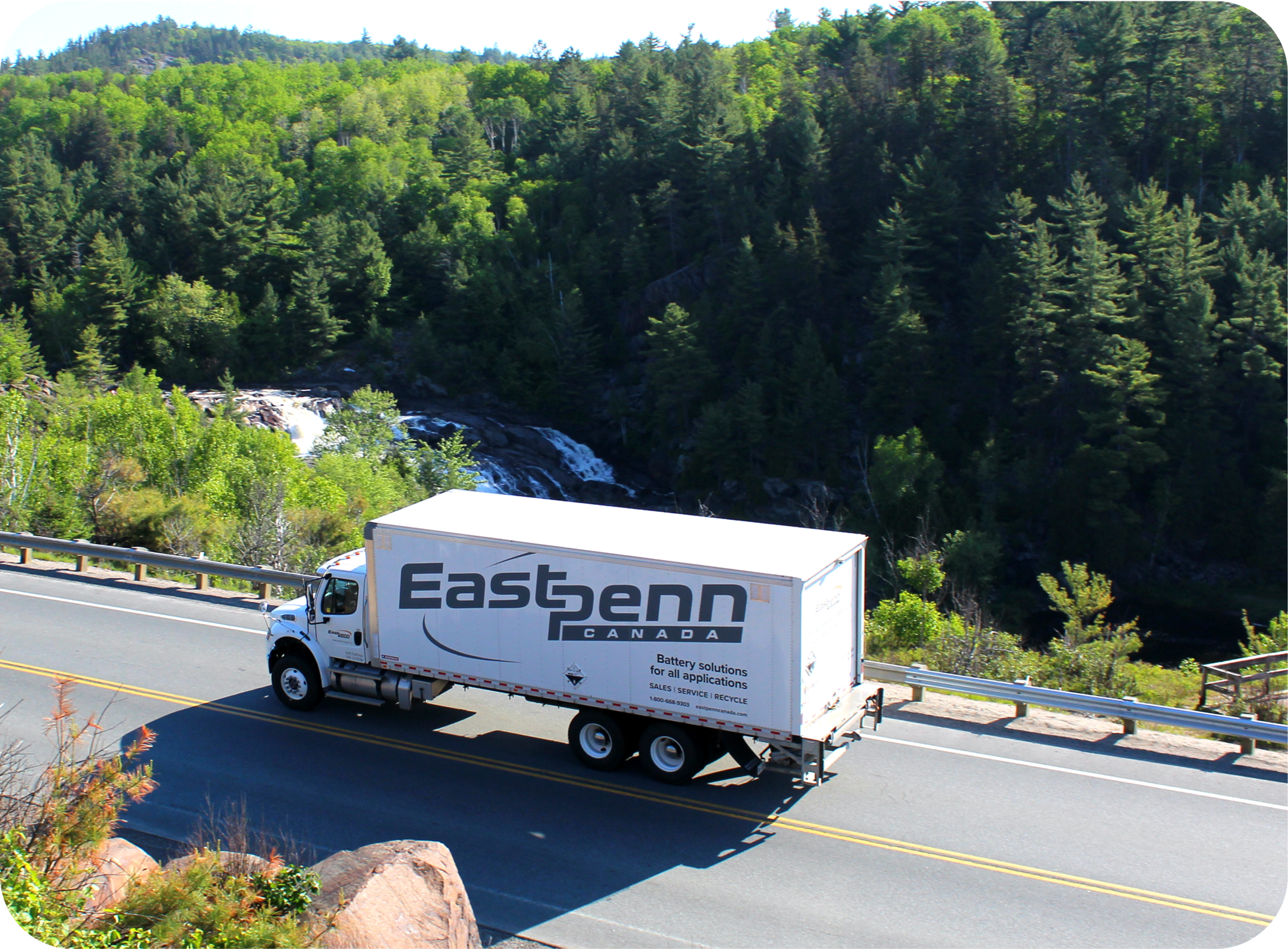 Picture of birds eye view of East Penn branded truck on a highway surrounded by trees