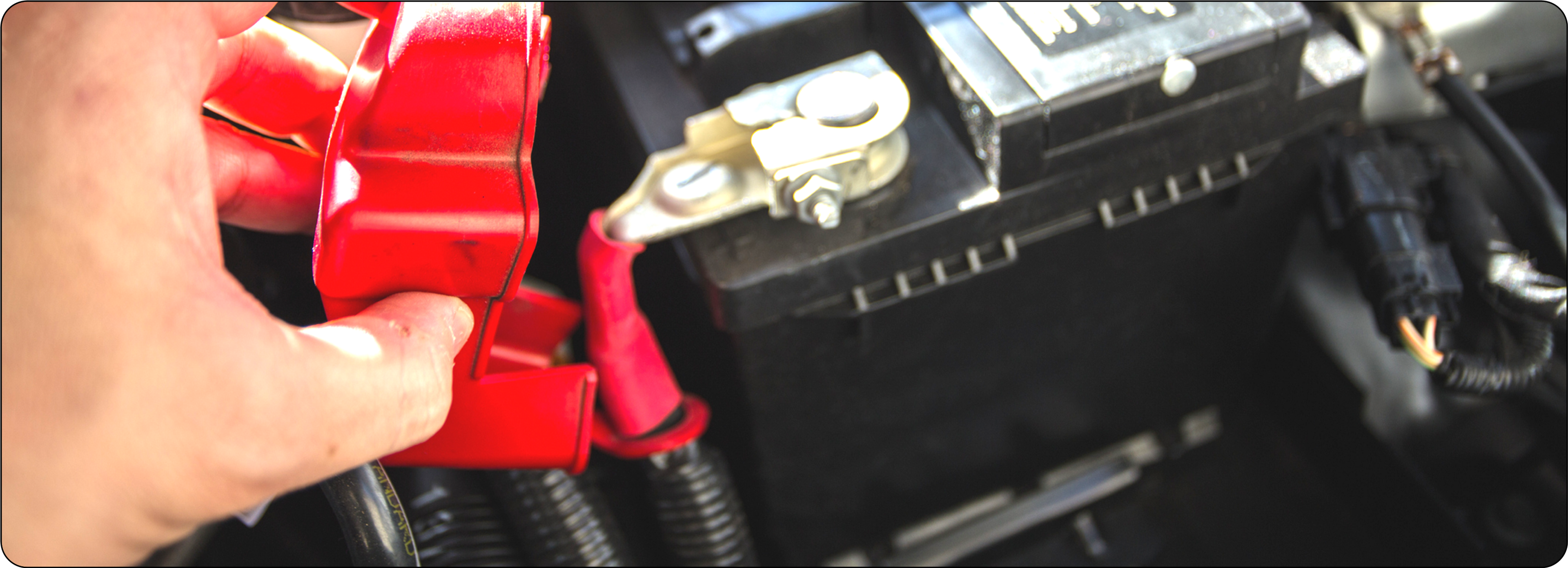 Picture of a man's hand handling a car battery