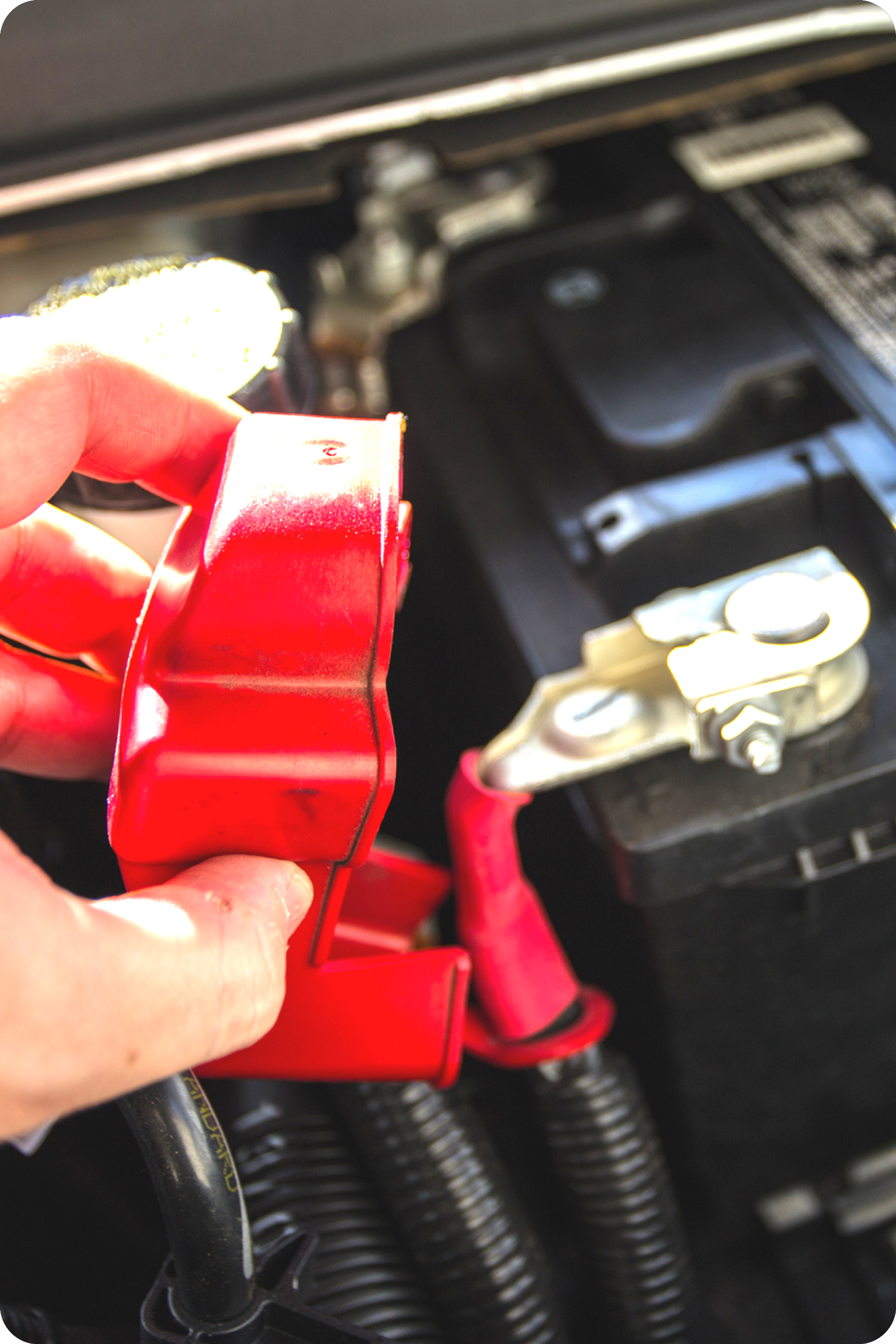 Photo d'une main d'homme manipulant une batterie automobile