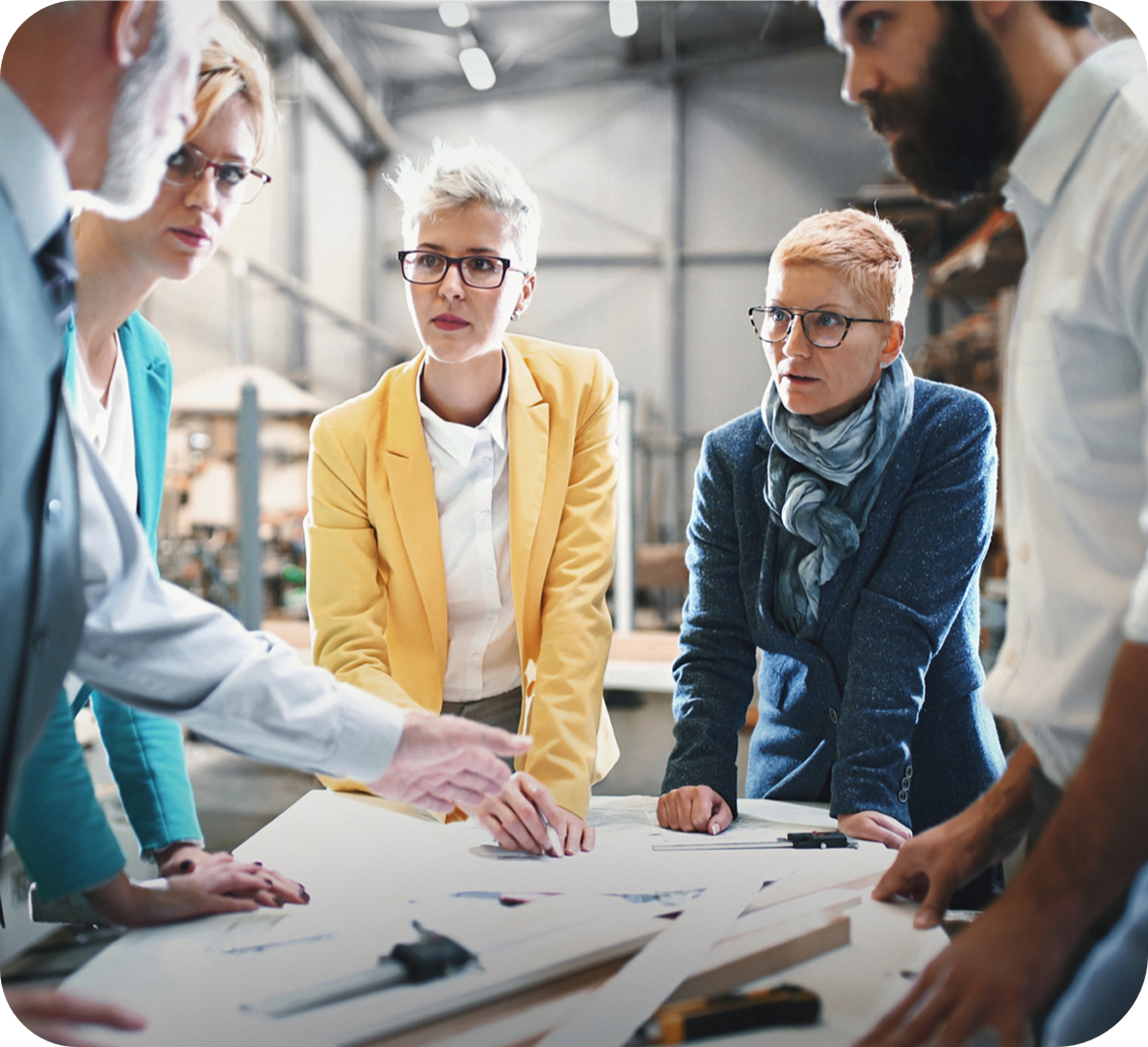 Image of man explaining a concept to three women with short hair and wearing blazers