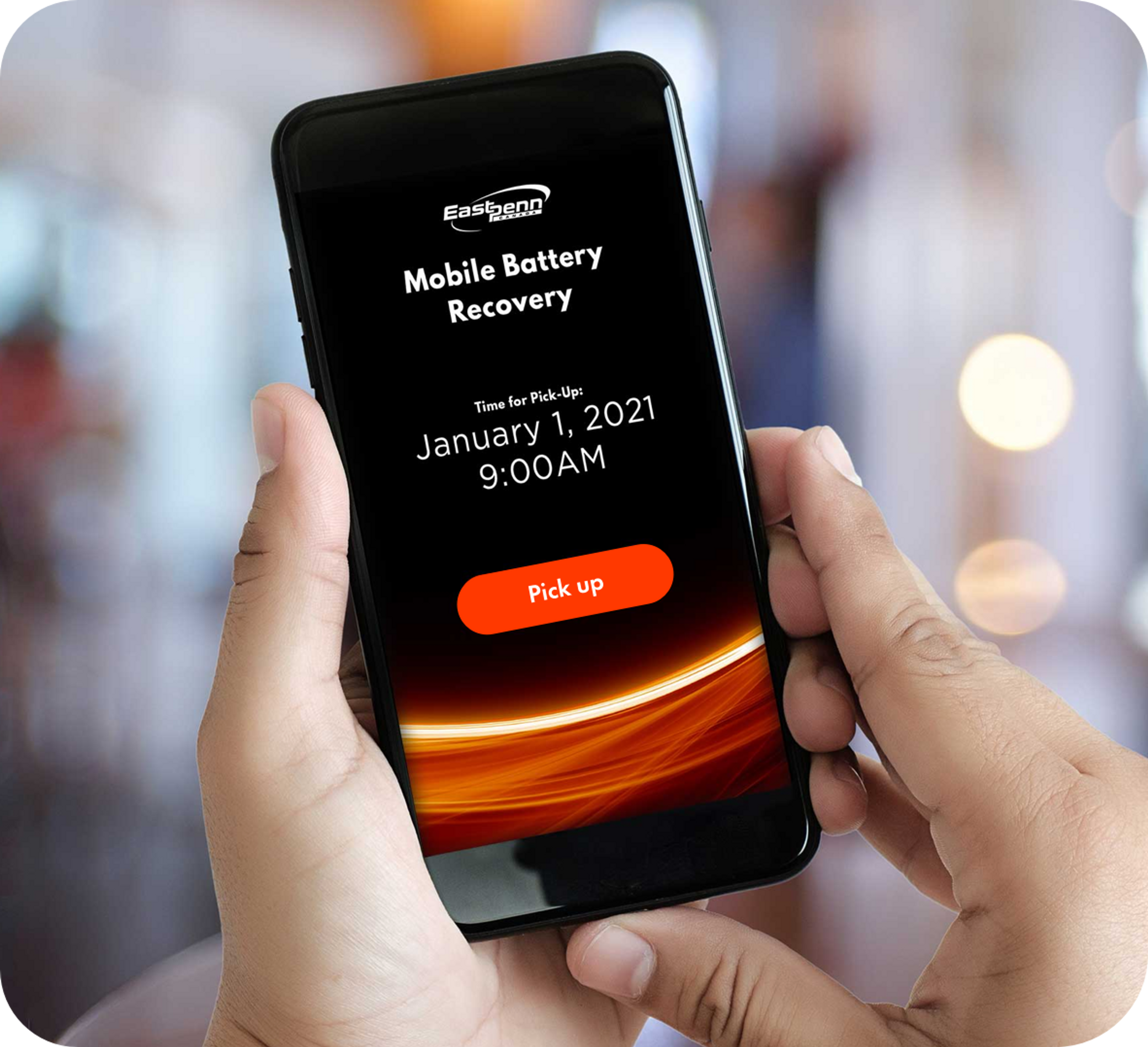 Picture of a man holding a phone in his hands with the screen showing East Penn Mobile Battery recovery app