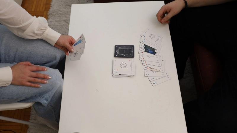 Two players playing Crazy Aces, where one player has reached the maximum hand size and put their cards on the table in defeat.