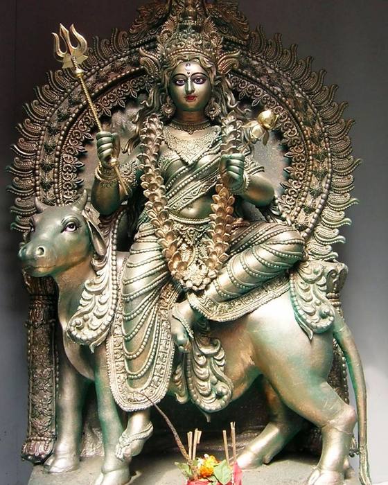 A silver-toned idol of Devi Shailaputri seated on her bull mount Nandi, holding a trishul in her right hand and a lotus in her left, worshipped during Durga Puja