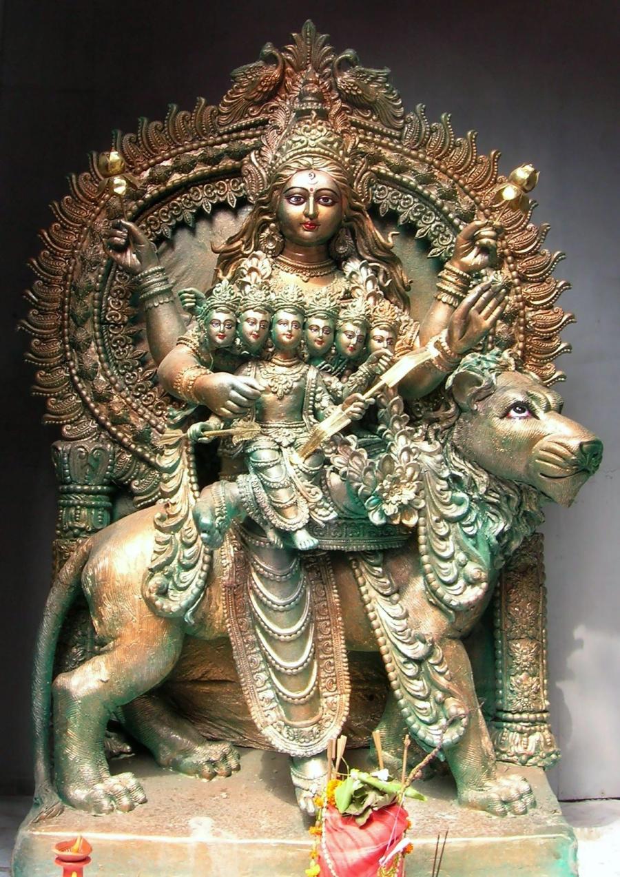 A bronze idol of Devi Skandamata seated on her lion mount, holding the infant six-headed Skanda (Kartikeya) on her lap, worshipped during Durga Puja